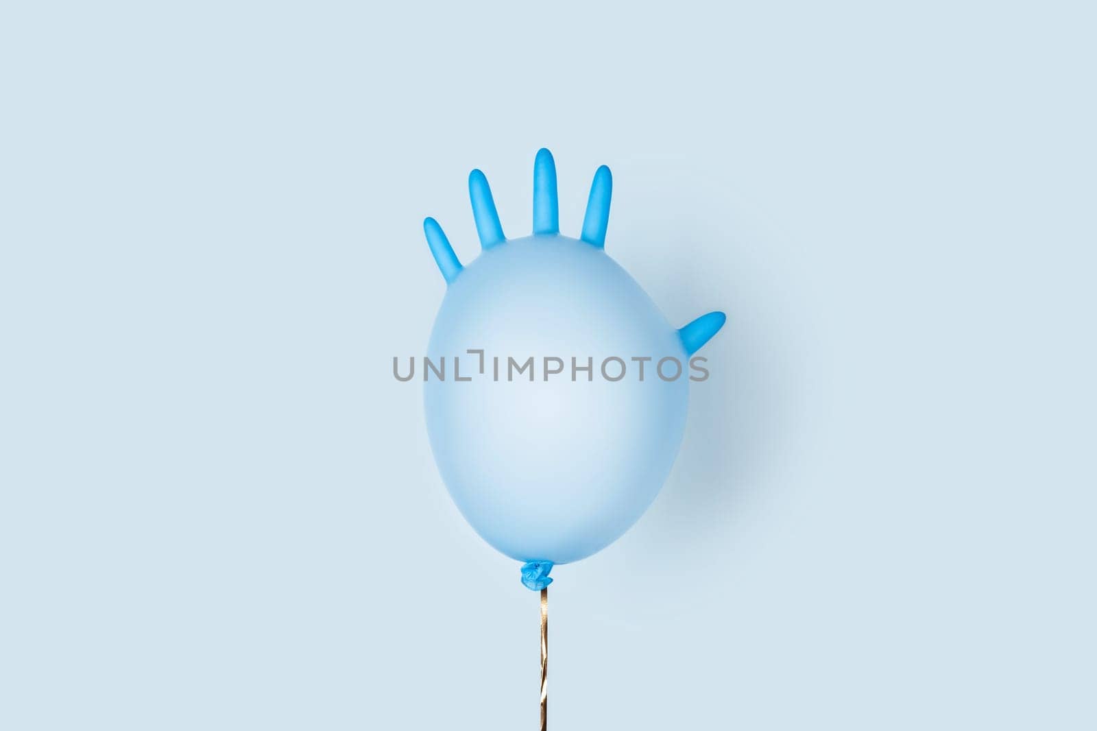 Happy anniversary concept on self-isolation and social distancing. A festive ball made of medical glove on a blue background.