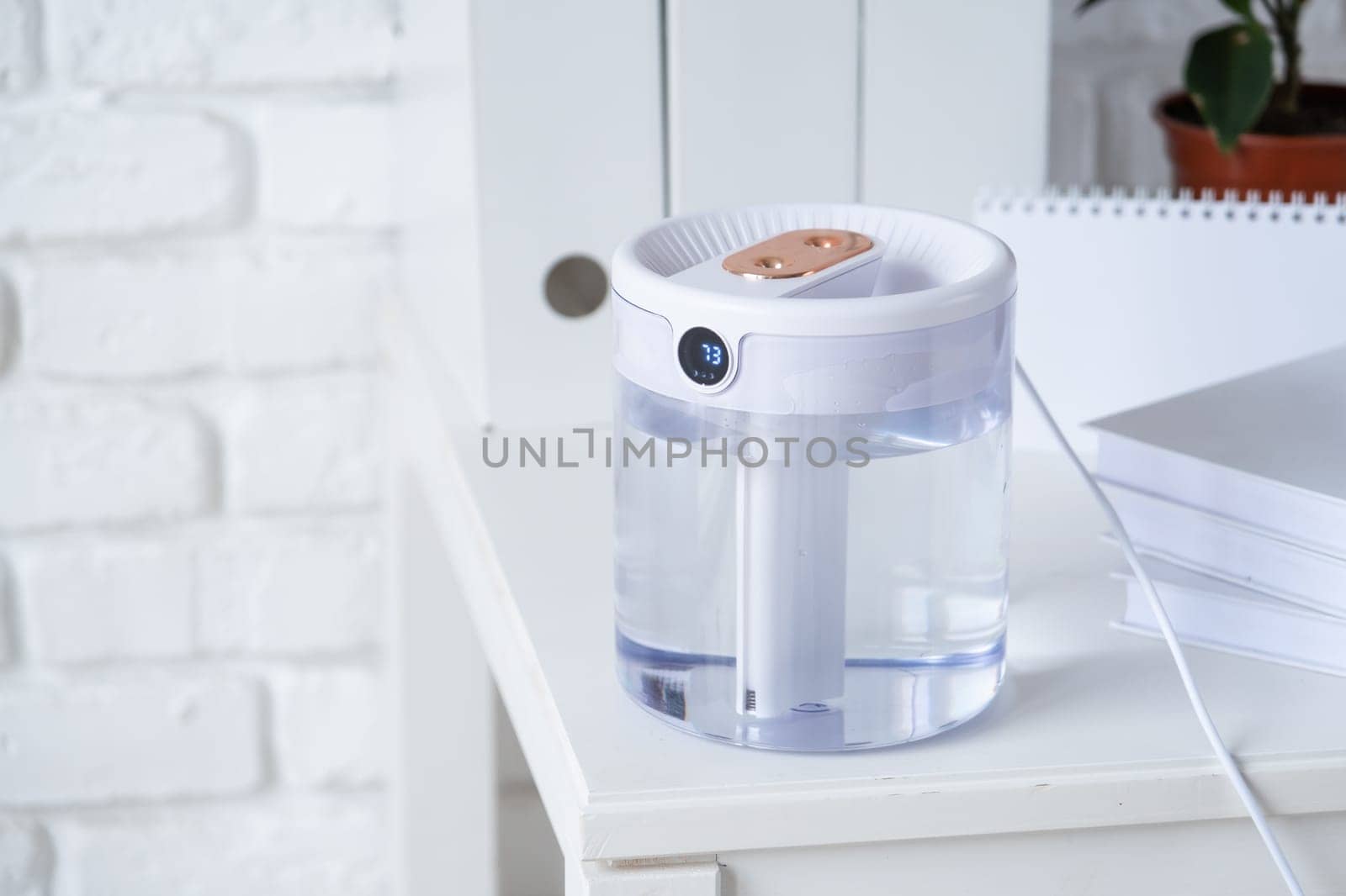 Modern air humidifier on table in living room or office . Space for text by Desperada