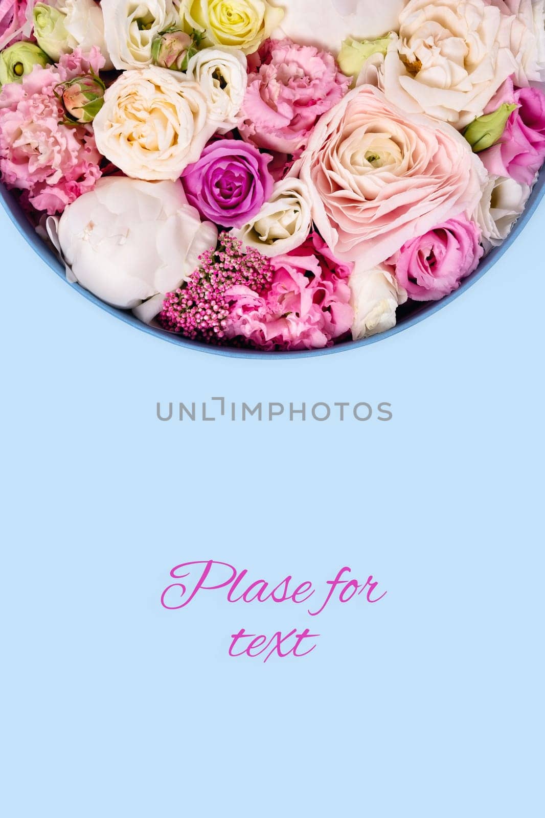 Blue background with hat box and flowers. Vertical flatlay picture.