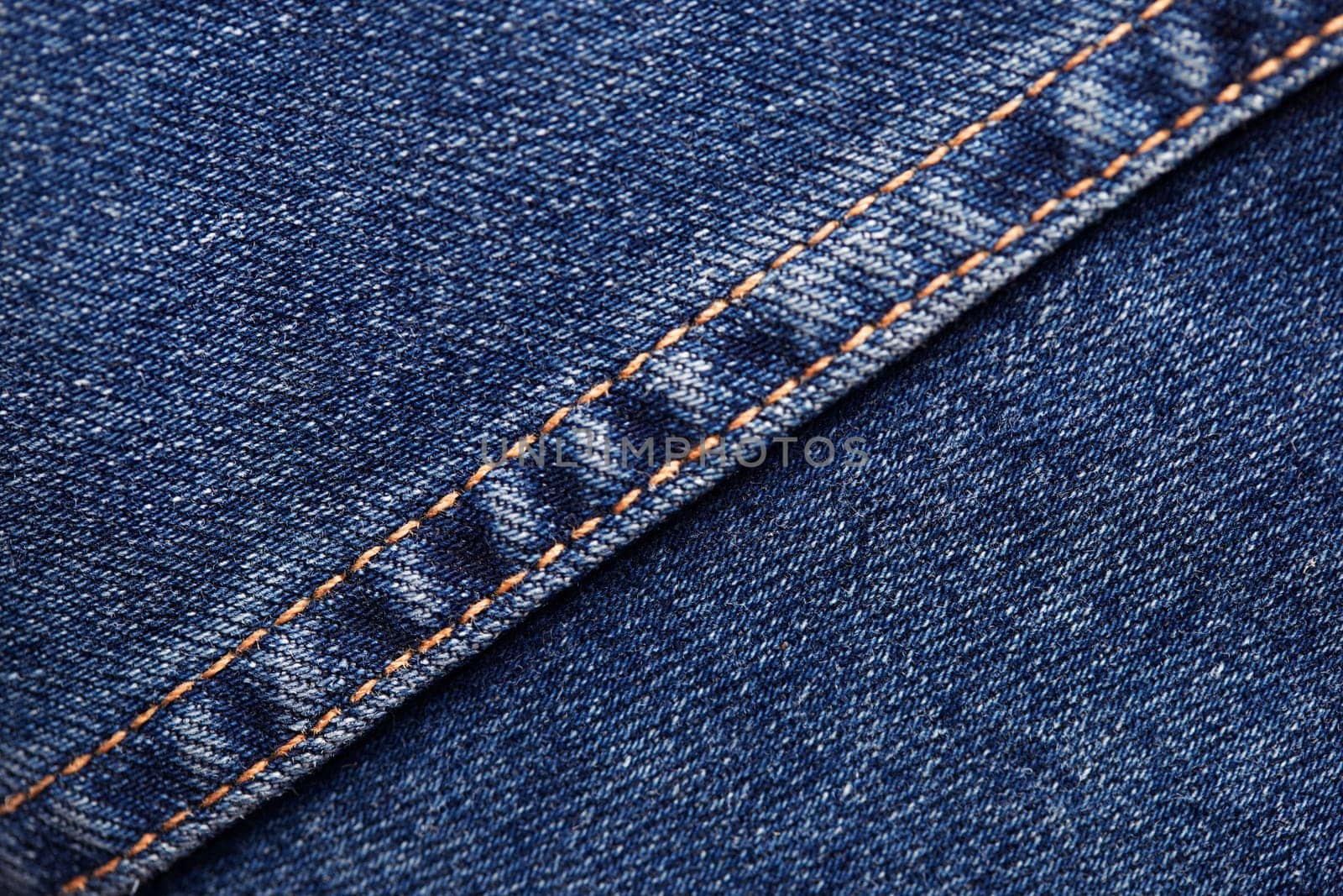 Seams on jeans close-up. Stitching on denim. Fabric texture. Blue jeans background and texture. Close up of blue jeans background. Denim texture in high-resolution.