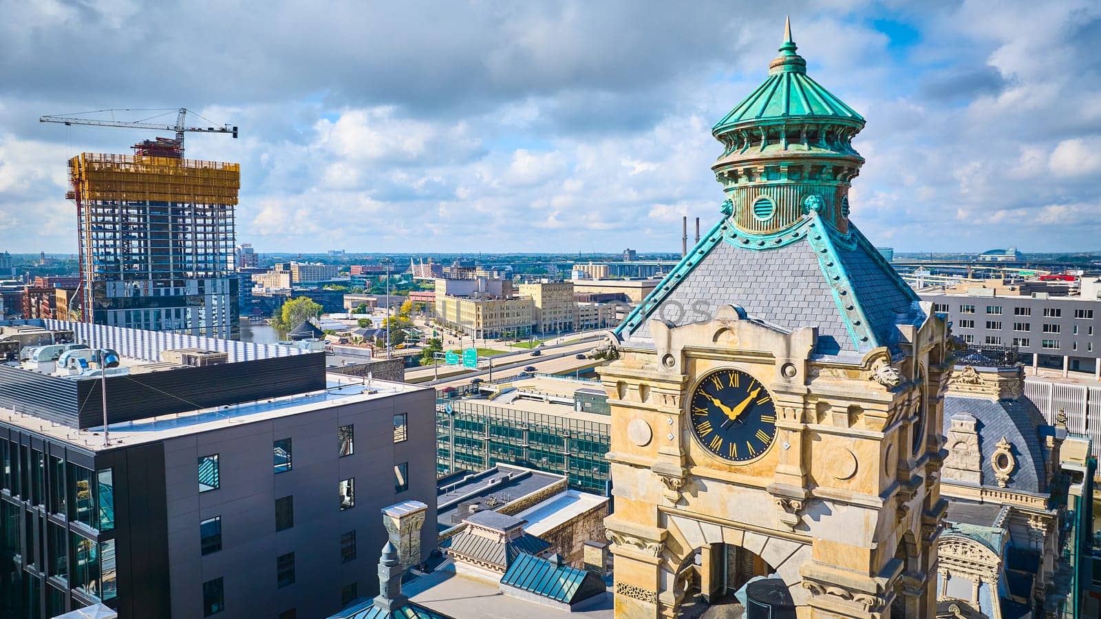 Historical Clock Tower and Ongoing High-Rise Construction in Vibrant Milwaukee Cityscape, Captured by Drone