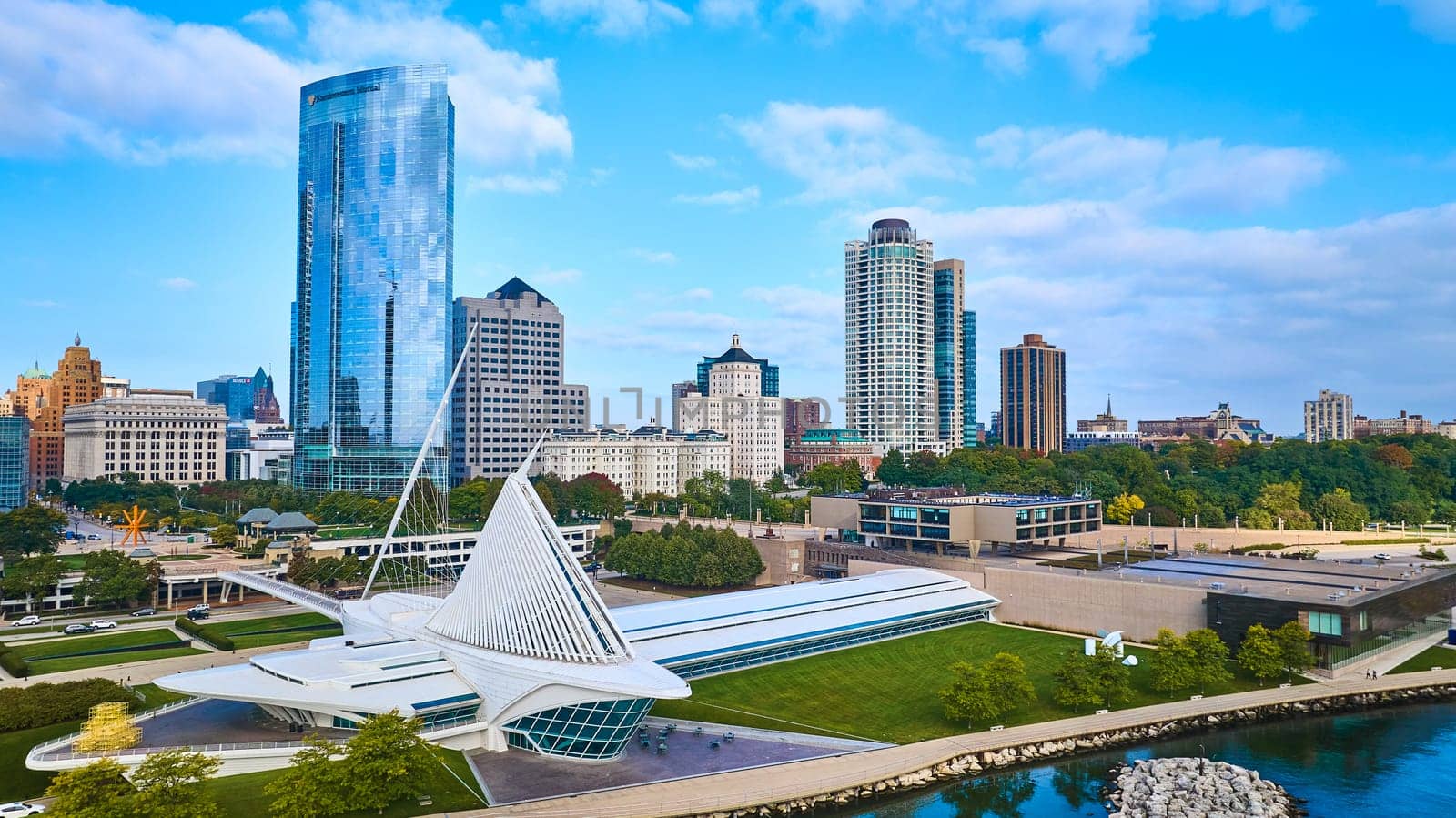 Daytime view of Milwaukee's diverse architecture, featuring the modern Quadracci Pavilion and towering skyscraper, captured by a DJI Mavic 3 drone.