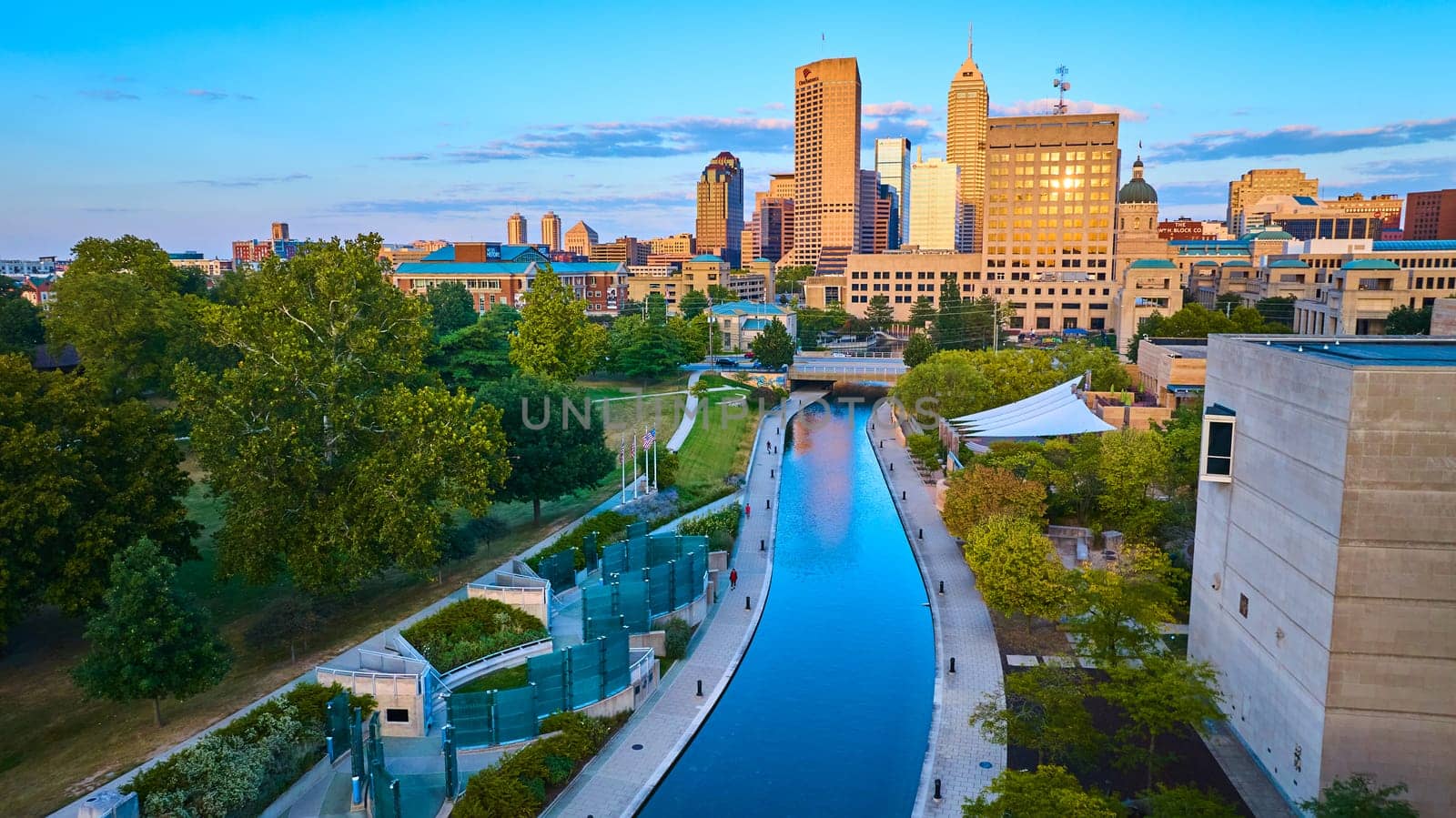 Sunset Glow on Indianapolis: Aerial View of Urban Development and Canal, Captured by Drone