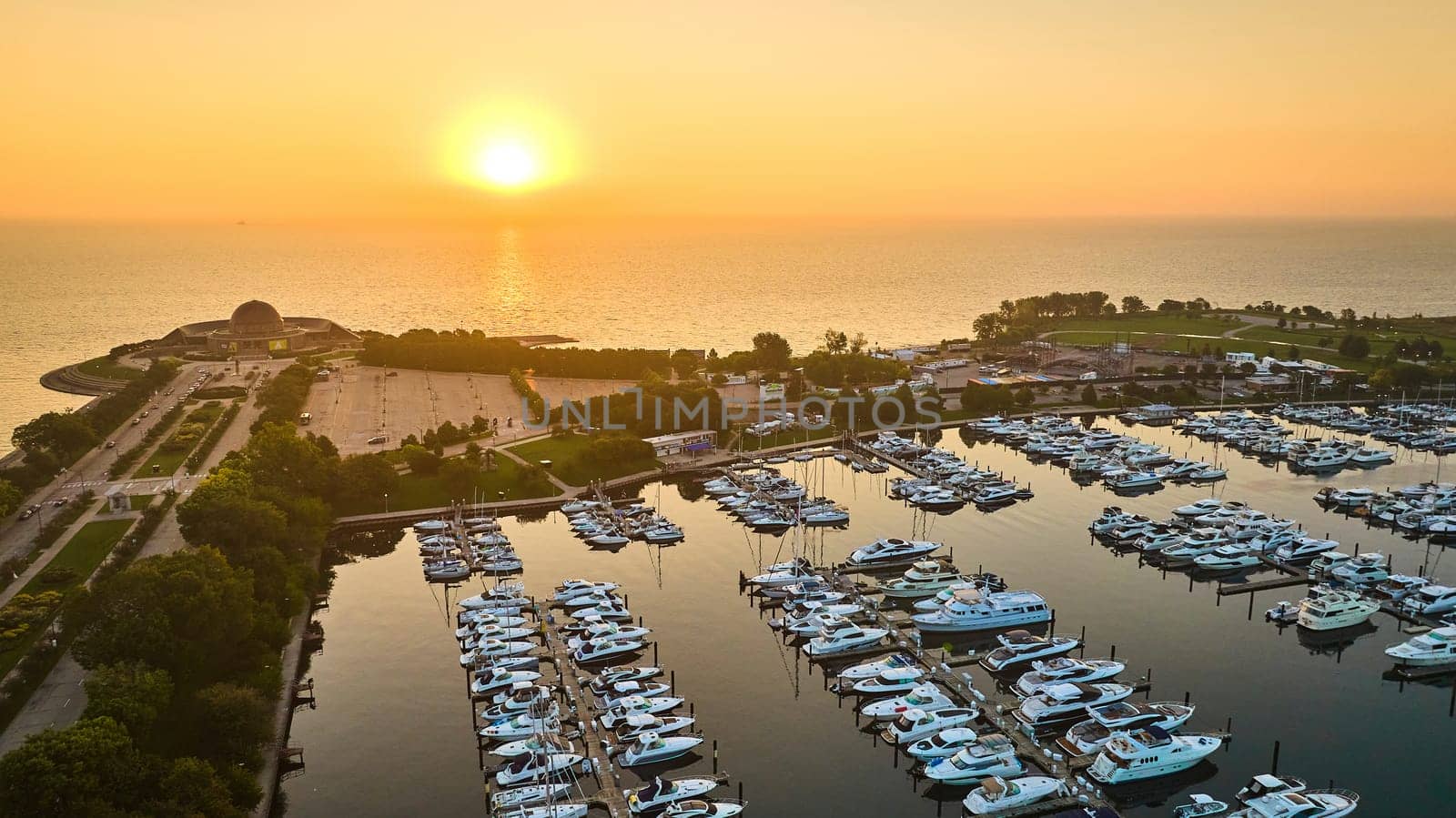 Image of Boats on piers in Burnham Harbor with golden sun rising aerial Lake Michigan, Chicago, IL