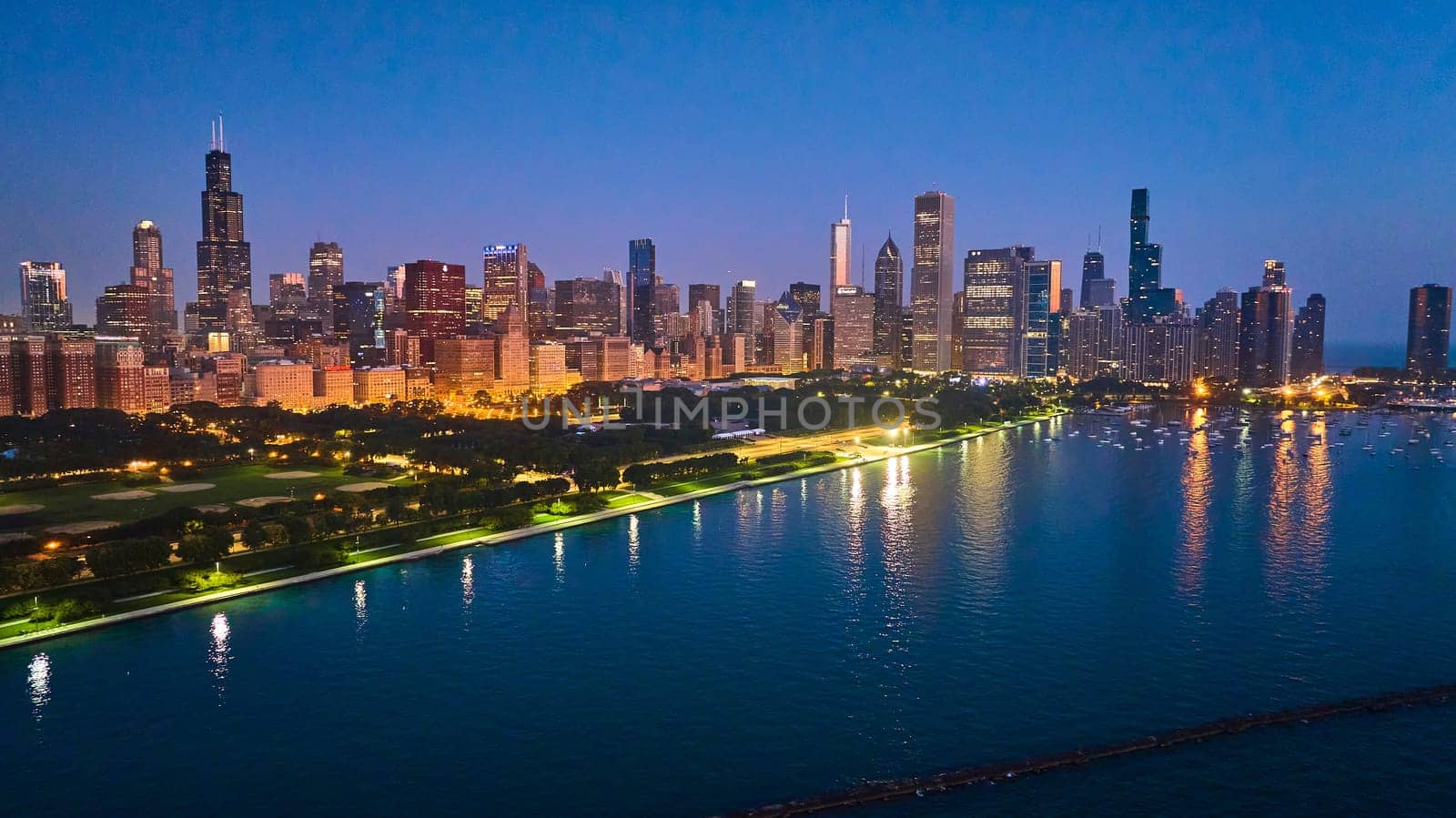 Image of Chicago coast aerial with city lights reflected at night on Lake Michigan water near harbor