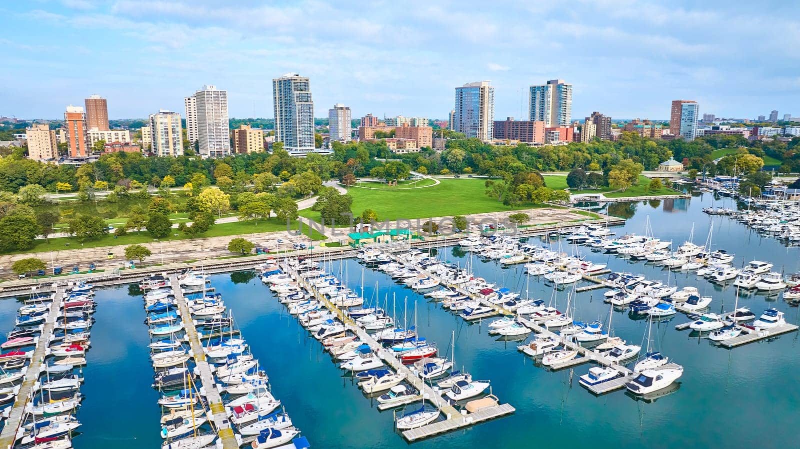 Aerial View of Vibrant Marina with Sailboats, Lush Park, and City Skyline in Milwaukee, Wisconsin