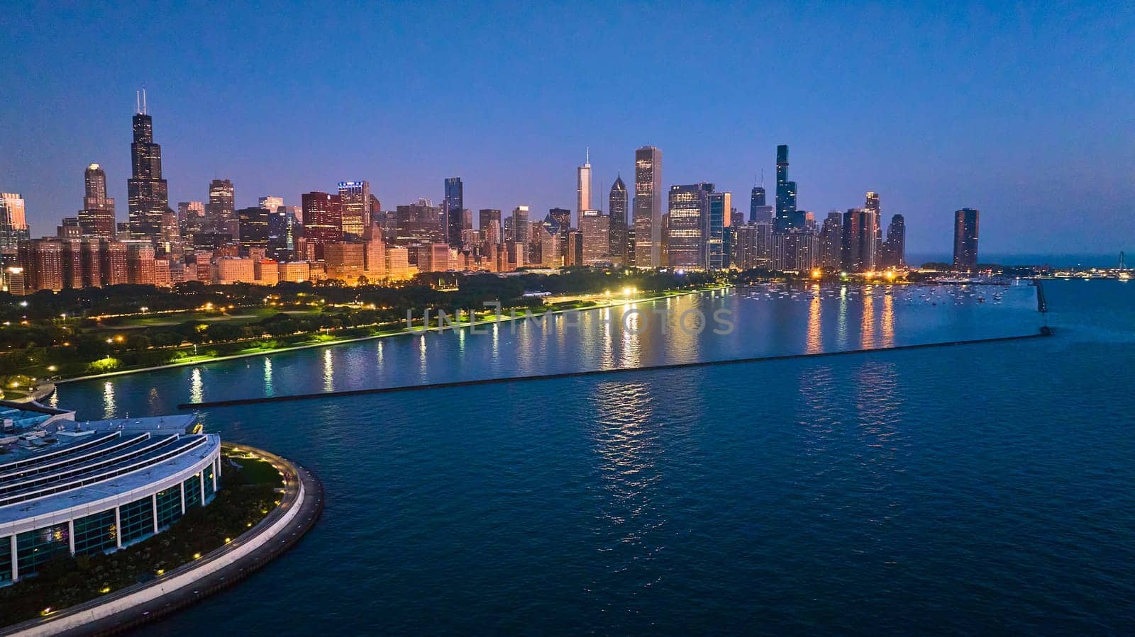 Chicago coast aerial with city lights reflected at night on Lake Michigan water near Shedd Aquarium by njproductions