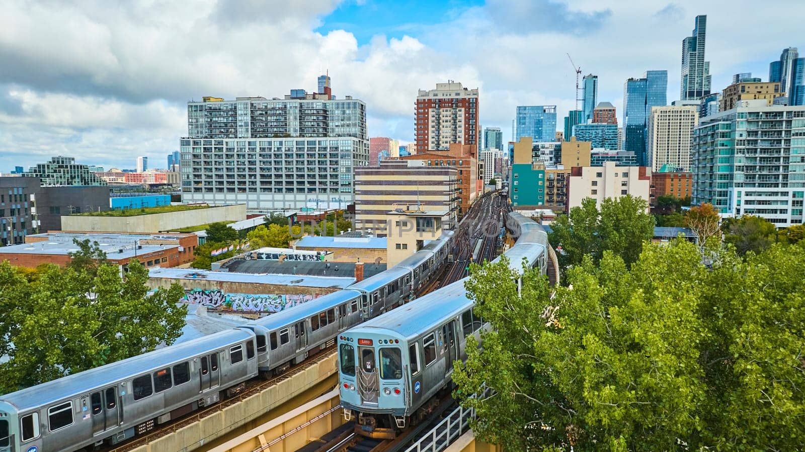 Trains on train track in Chicago aerial with big city skyscrapers in background, tourism, travel by njproductions