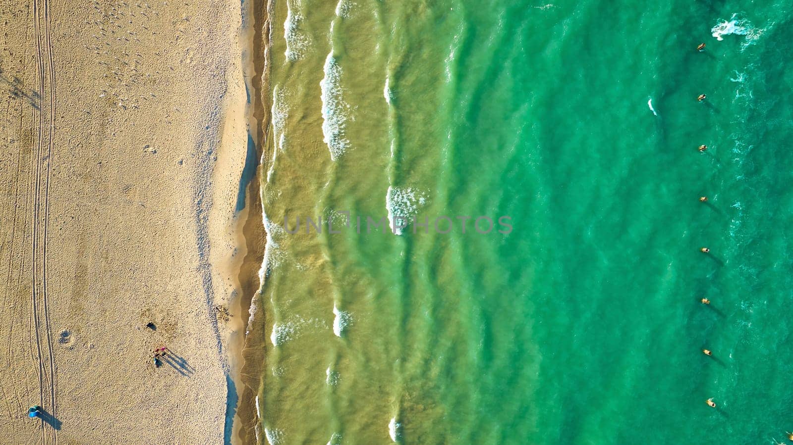 Green water along sandy beach aerial of sunny waves and water, tourist, tourism and travel by njproductions