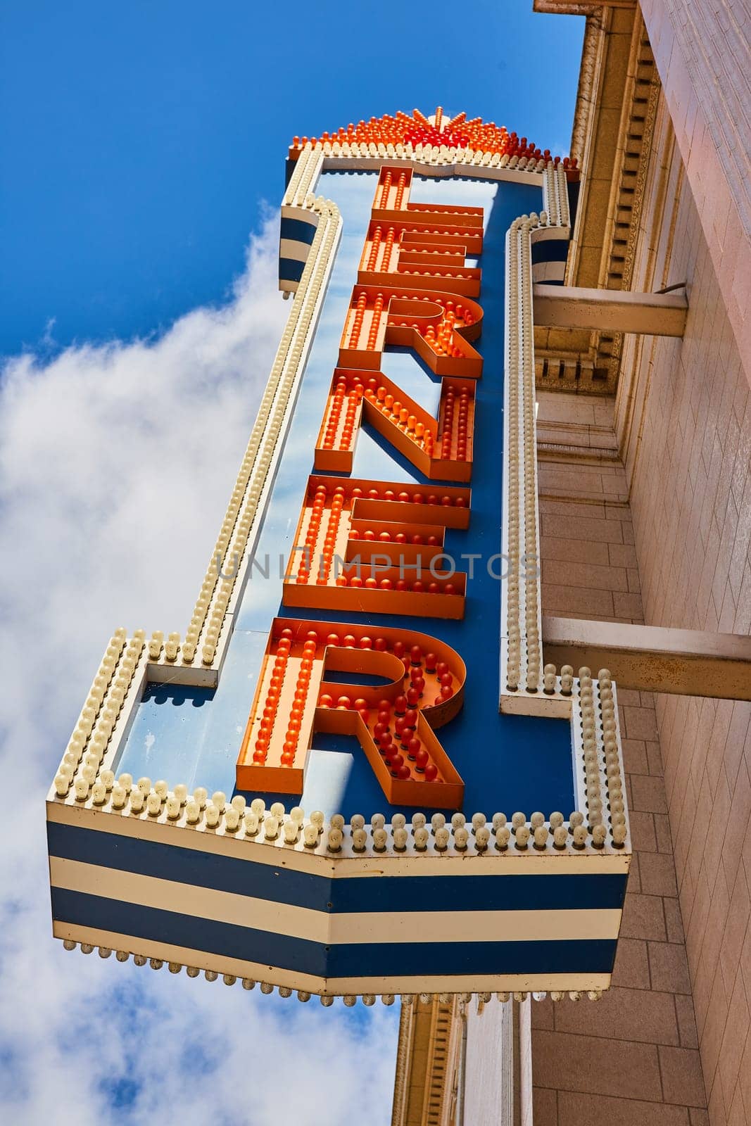 Vintage downtown movie theatre marquee sign in Elkhart, Indiana, radiating the golden age of Hollywood nostalgia against a sunny blue sky backdrop