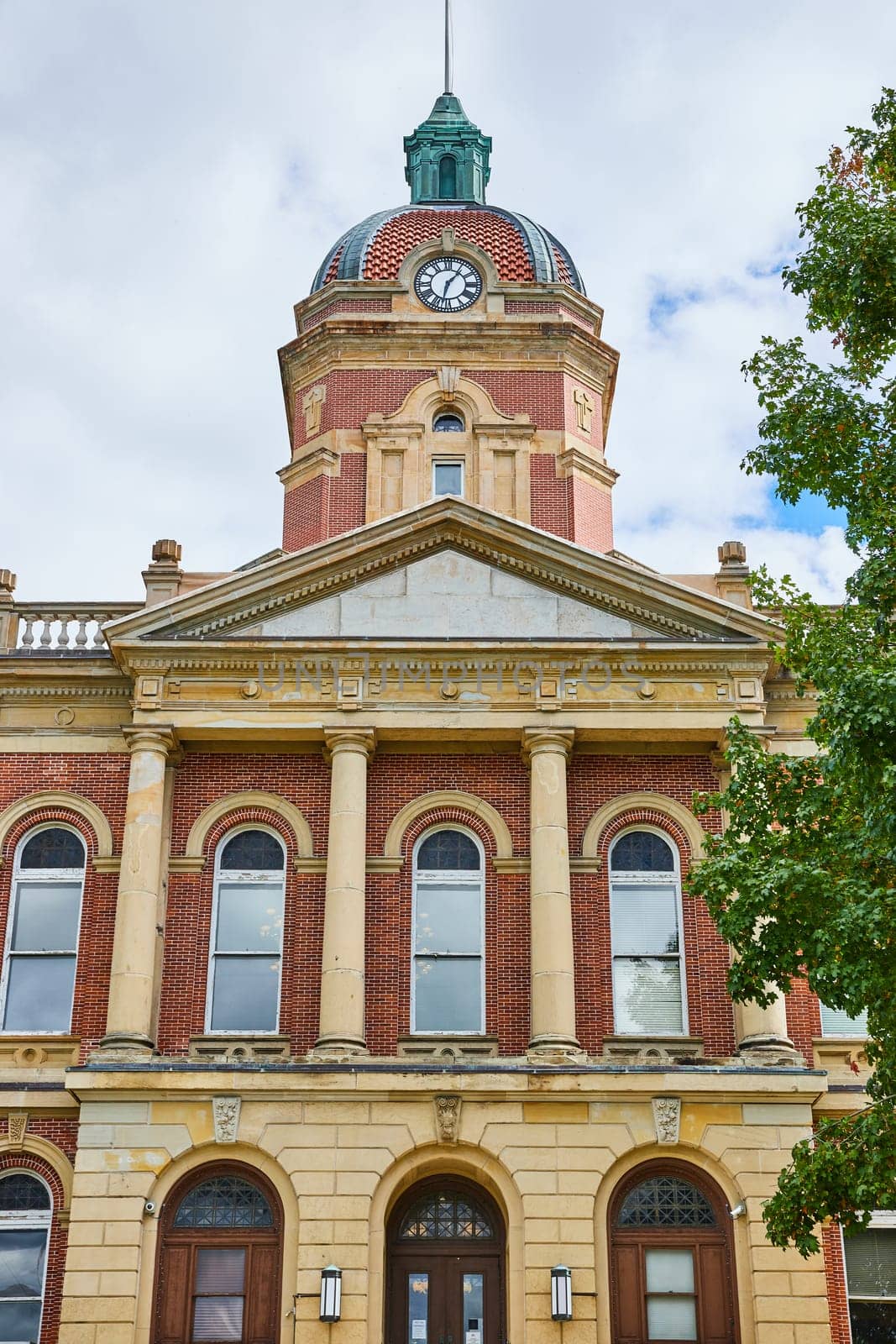 Image of Front of Elkhart County courthouse on cloudy day with fluffy white clouds, summer, Indiana