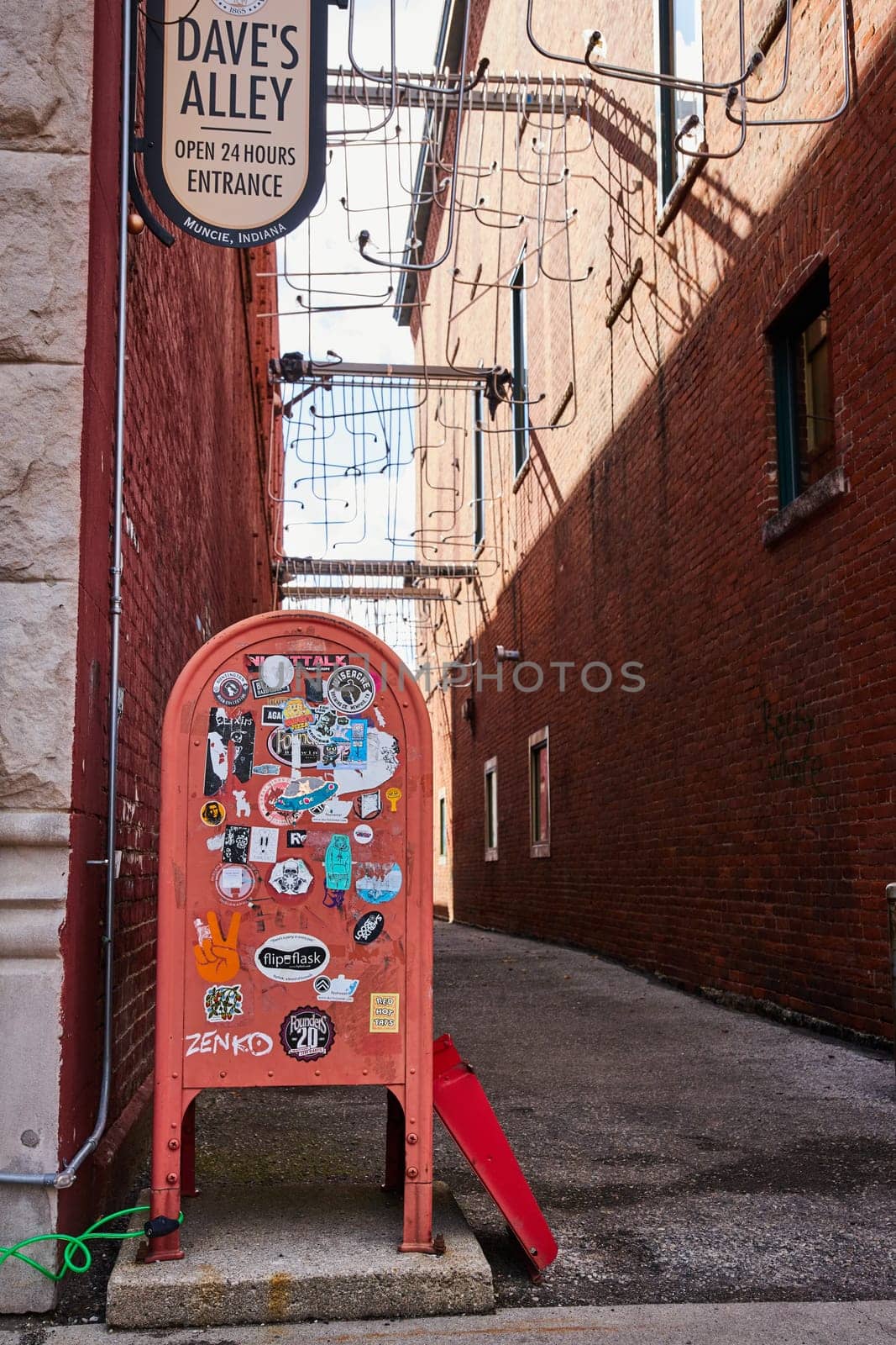 Vibrant urban scene at Dave's Alley, a 24-hour hub in downtown Muncie, Indiana, showcasing textured brick walls, colorful street art, and city life complexity, 2023