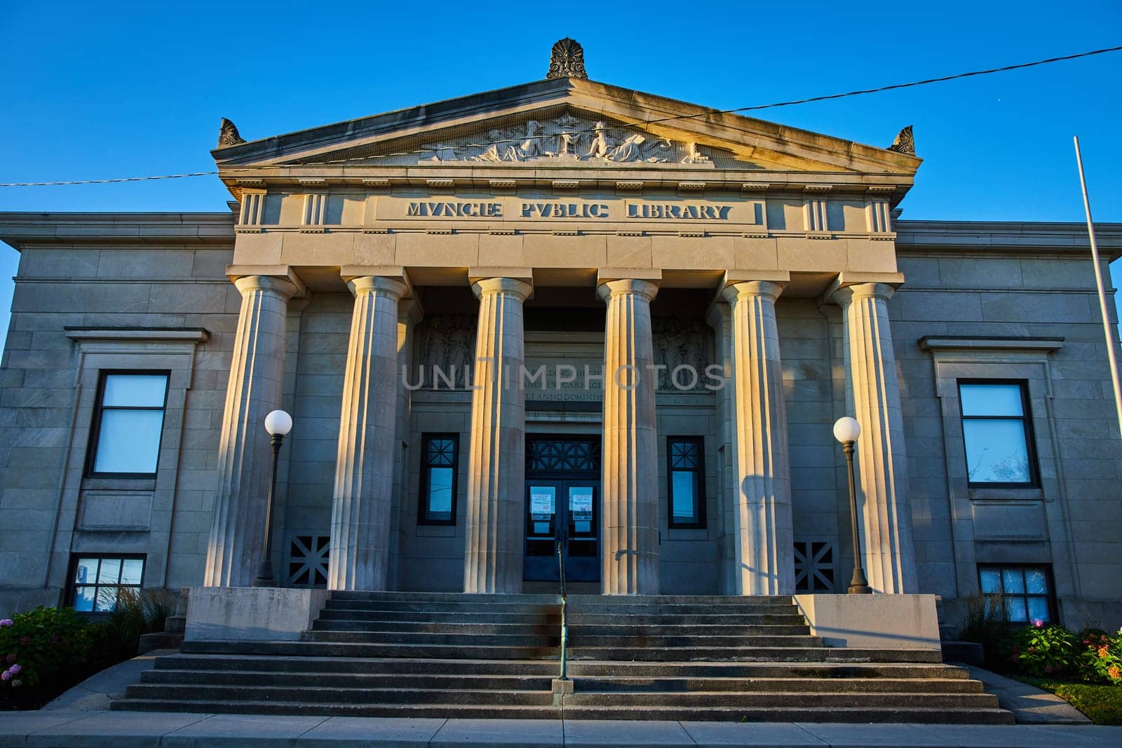 Carnegie-funded Muncie Public Library in Indiana, captured in the golden sunrise light, showcasing neoclassical architectural details