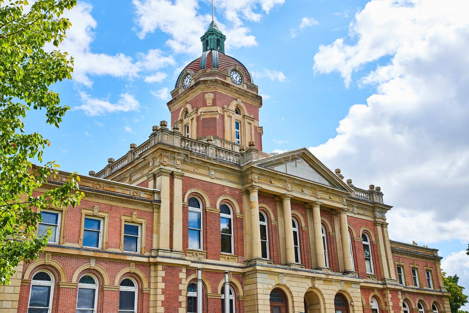 Image of Front of Elkhart County courthouse on blue sky day with fluffy white clouds, summer, Indiana