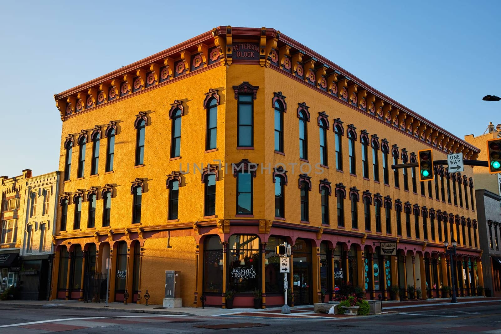 Golden hour illuminates the historic Patterson Block in downtown Muncie, Indiana, highlighting its rich architectural details and commercial charm