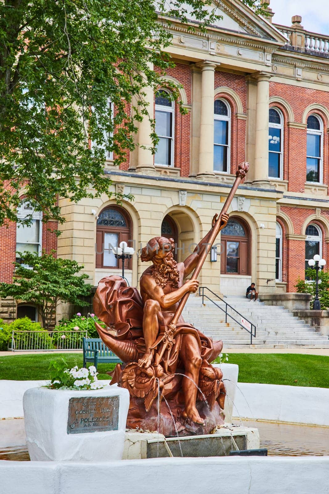 Image of Bronze Poseidon statue in fountain outside Elkhart County courthouse on summer day, law and order