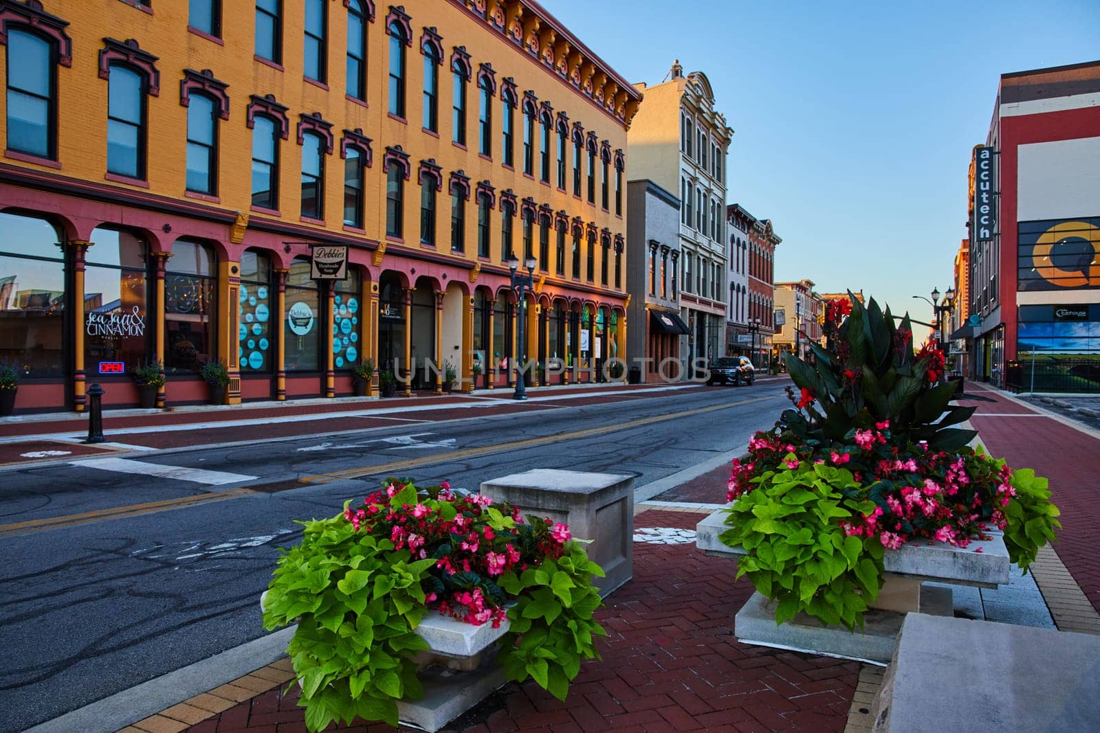 Golden hour sunrise over historic Muncie, Indiana downtown with vibrant flower planters and classic architecture