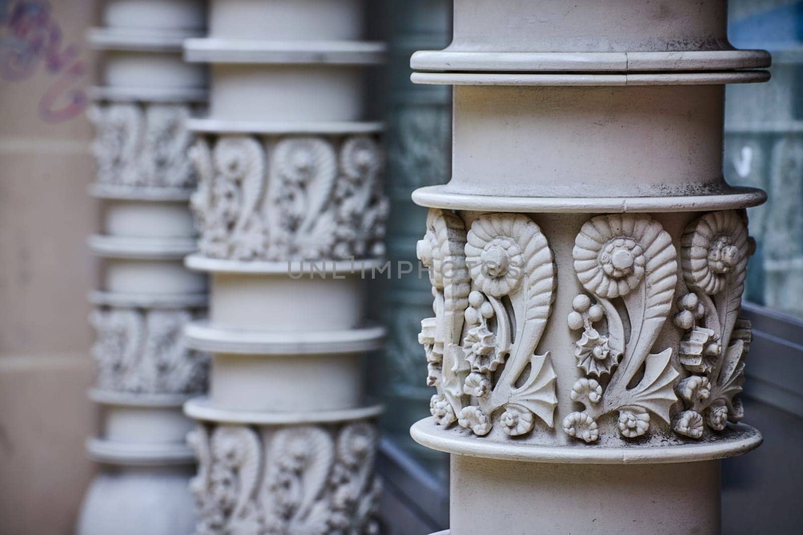 Image of White columns with seashell pattern in shape of number two repeated around pillar, background asset
