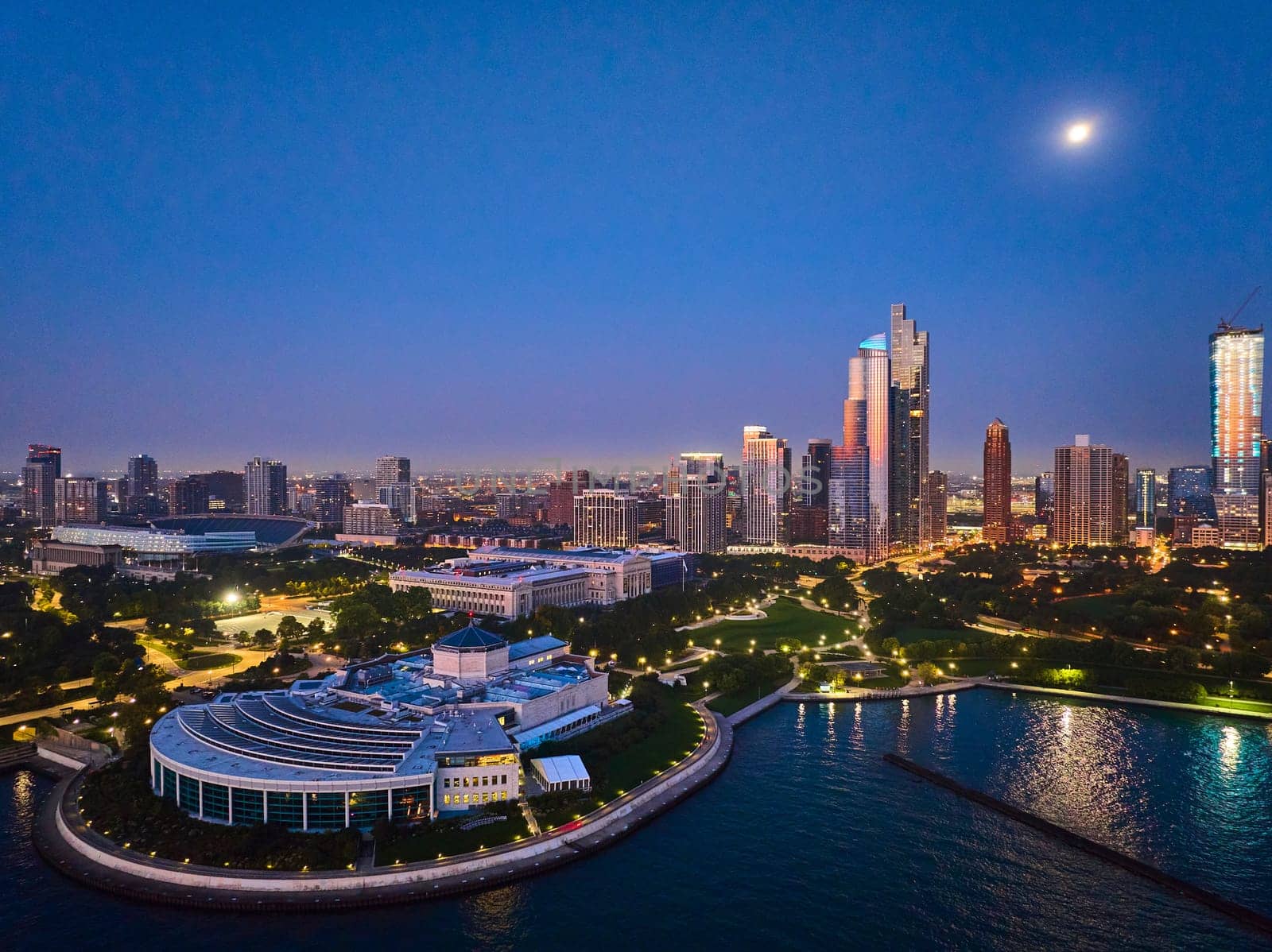 Shedd Aquarium aerial Chicago with moon over city lights at night with harbor and Lake Michigan by njproductions