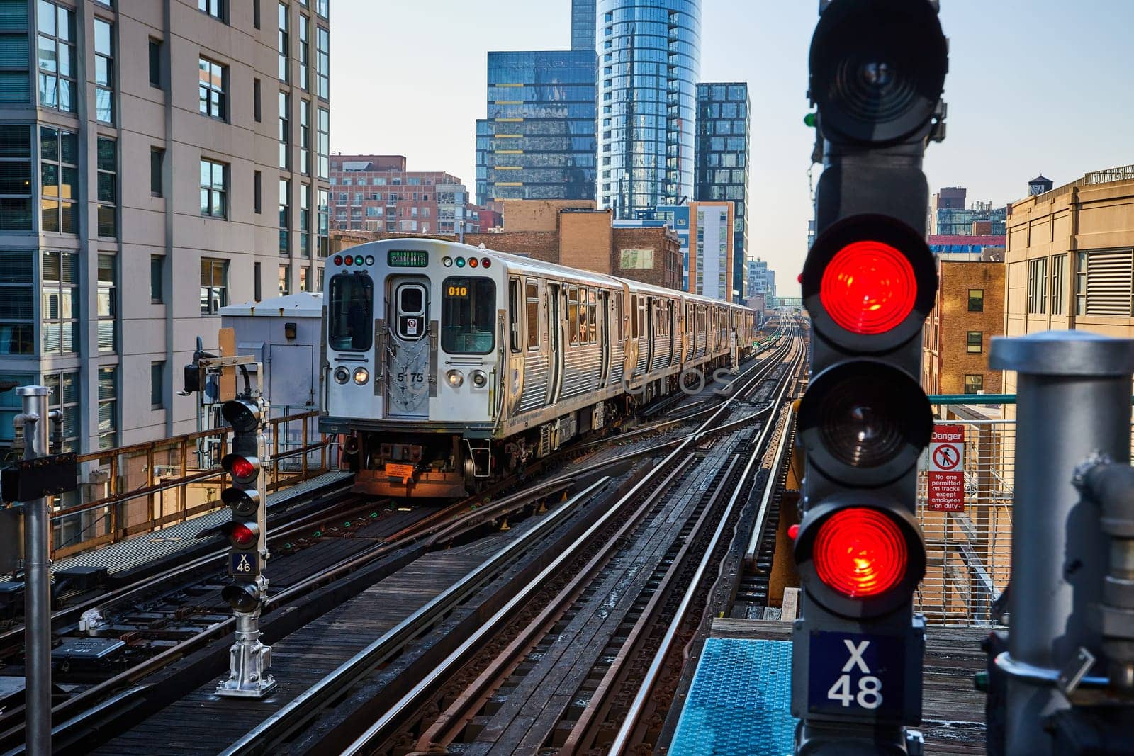 Bustling Chicago cityscape with a silver commuter train number 5175 moving along elevated tracks amidst modern buildings, symbolizing urban connectivity and efficient transportation