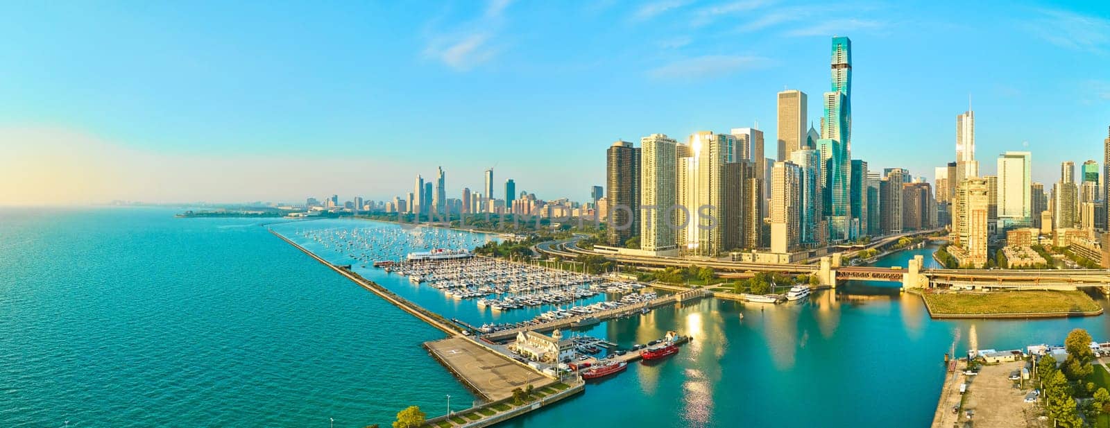 Aerial panorama of Chicago's vibrant skyline, serene Lake Michigan marina, and modern skyscrapers in golden hour light