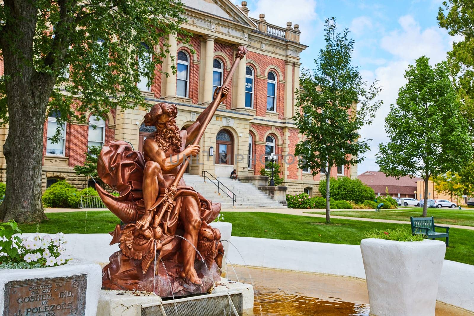 Image of Poseidon bronze statue in yellow fountain at Elkhart County courthouse in summer, law and order, IN
