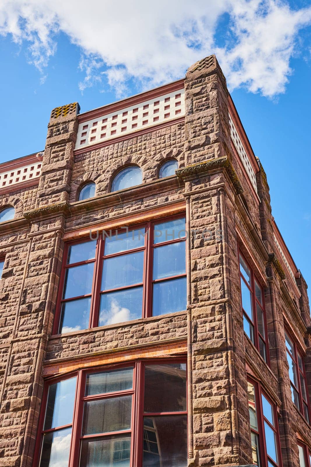 Sandstone Building Elegance with Arched Windows, Sunny Sky - Upward View by njproductions