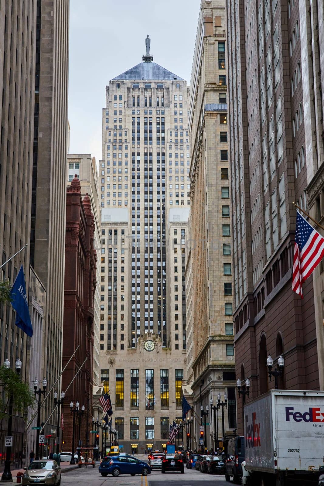 Image of Downtown Chicago Illinois street with patriotic American flag on building and city skyscrapers