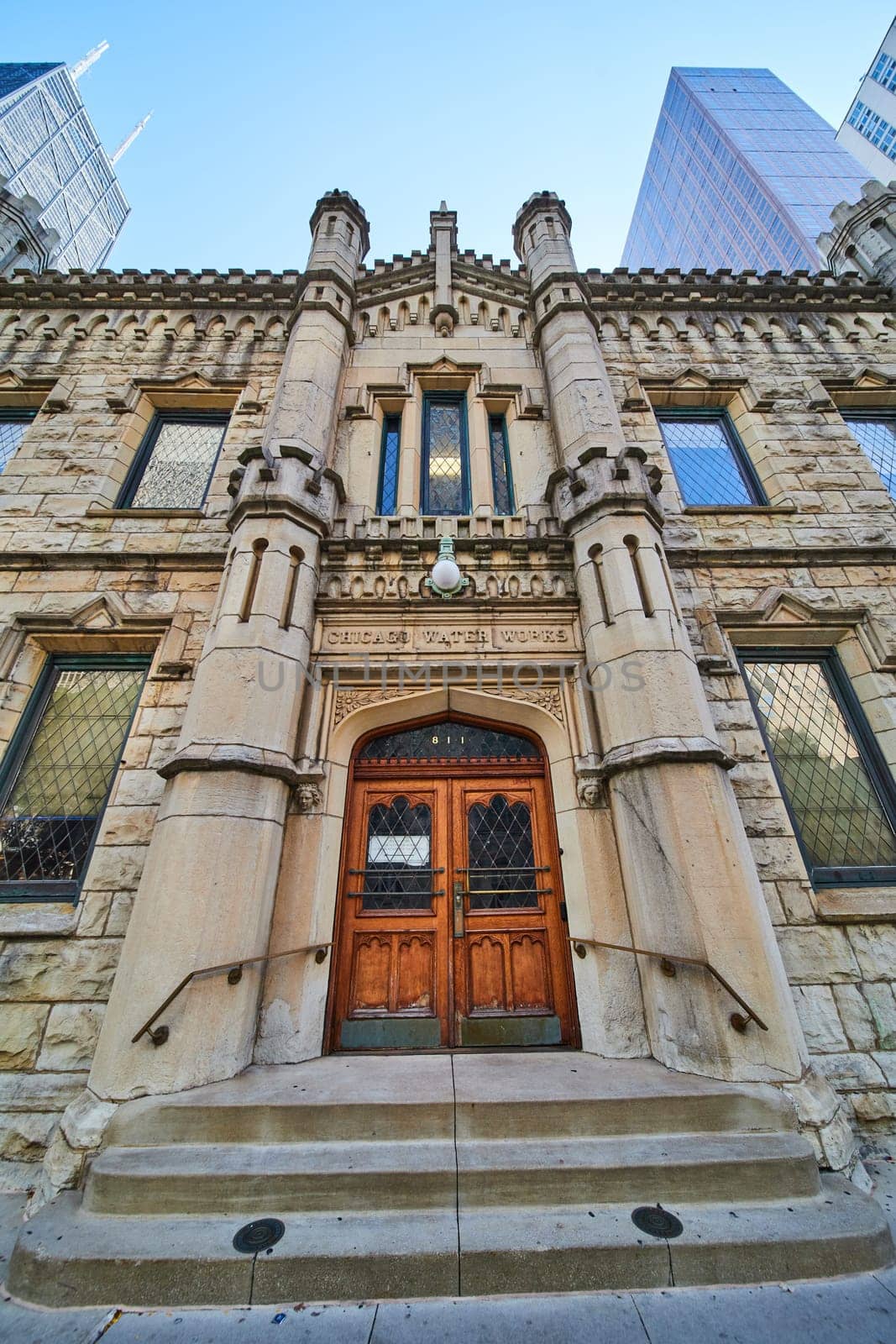 Image of Entrance Chicago Water Works castle like building architecture with steps and city skyscrapers