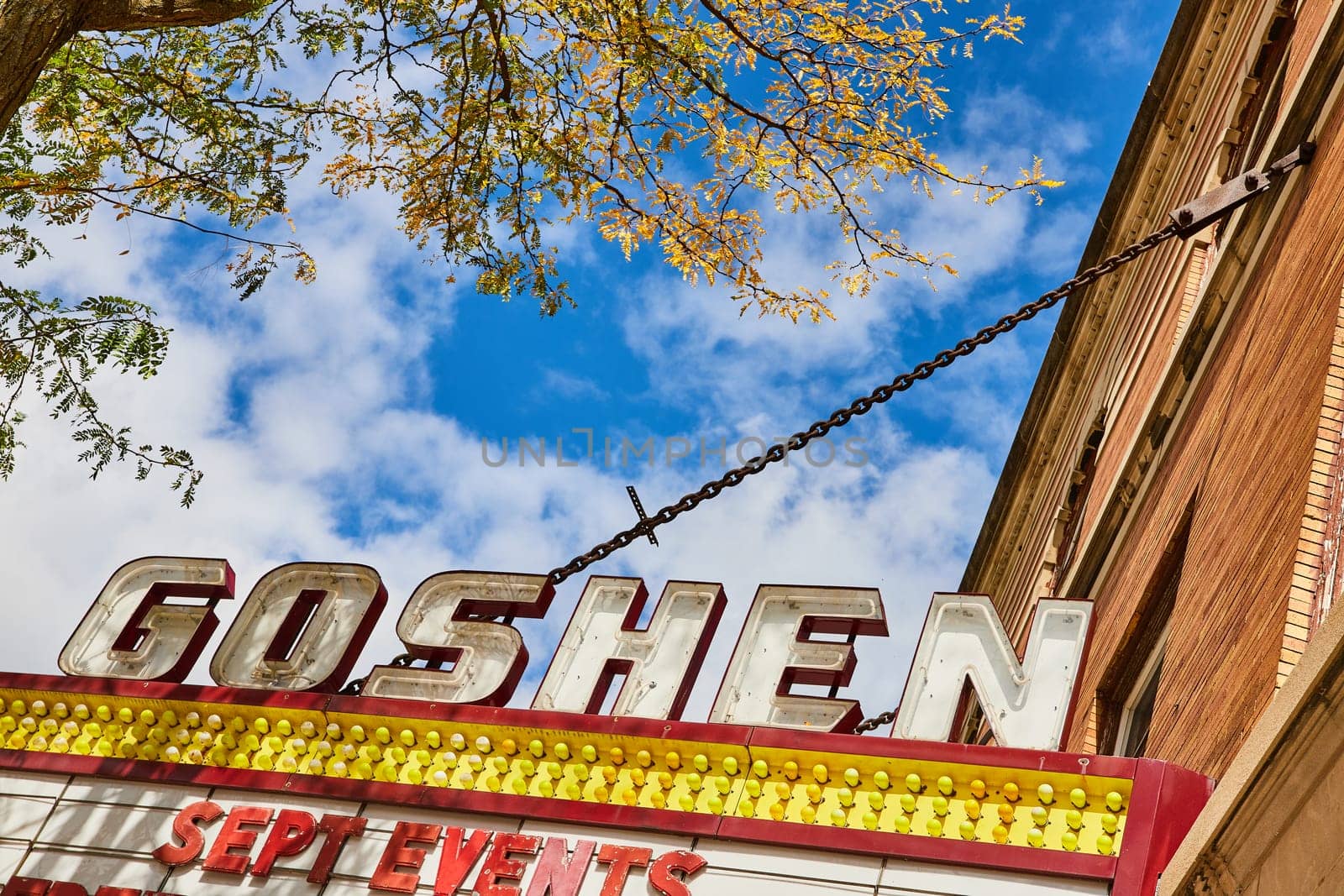 Image of Goshen theater sign on bright, sunny summer day with blue sky and white clouds, Indiana
