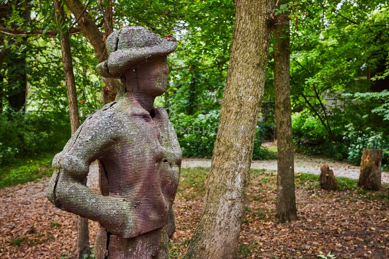 Textured sculpture of reflective figure in serene woodland setting at Art Center, Indianapolis, Indiana, 2023