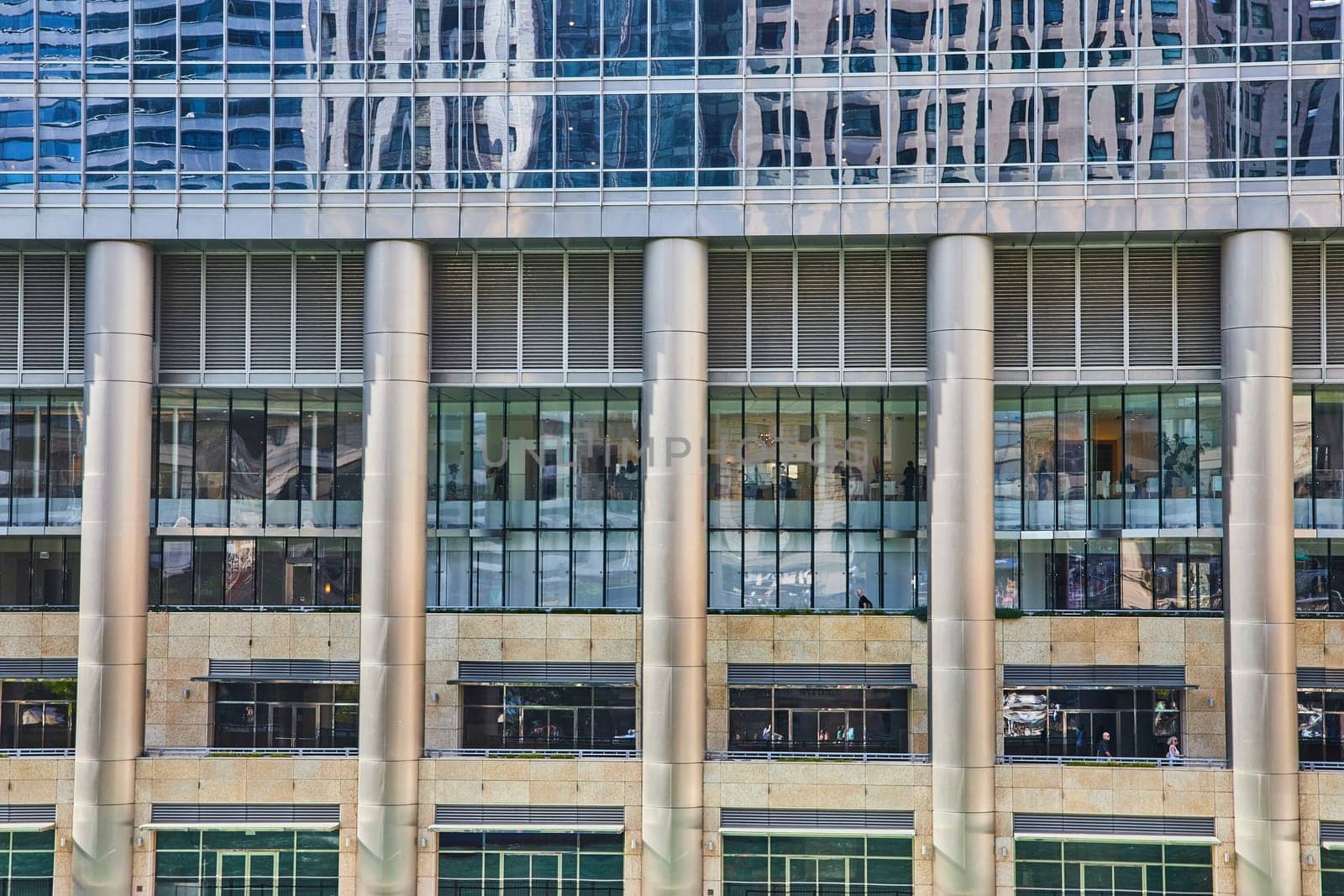 Image of Chrome pillars with reflective windows and bars between in architecture view of Chicago, IL building