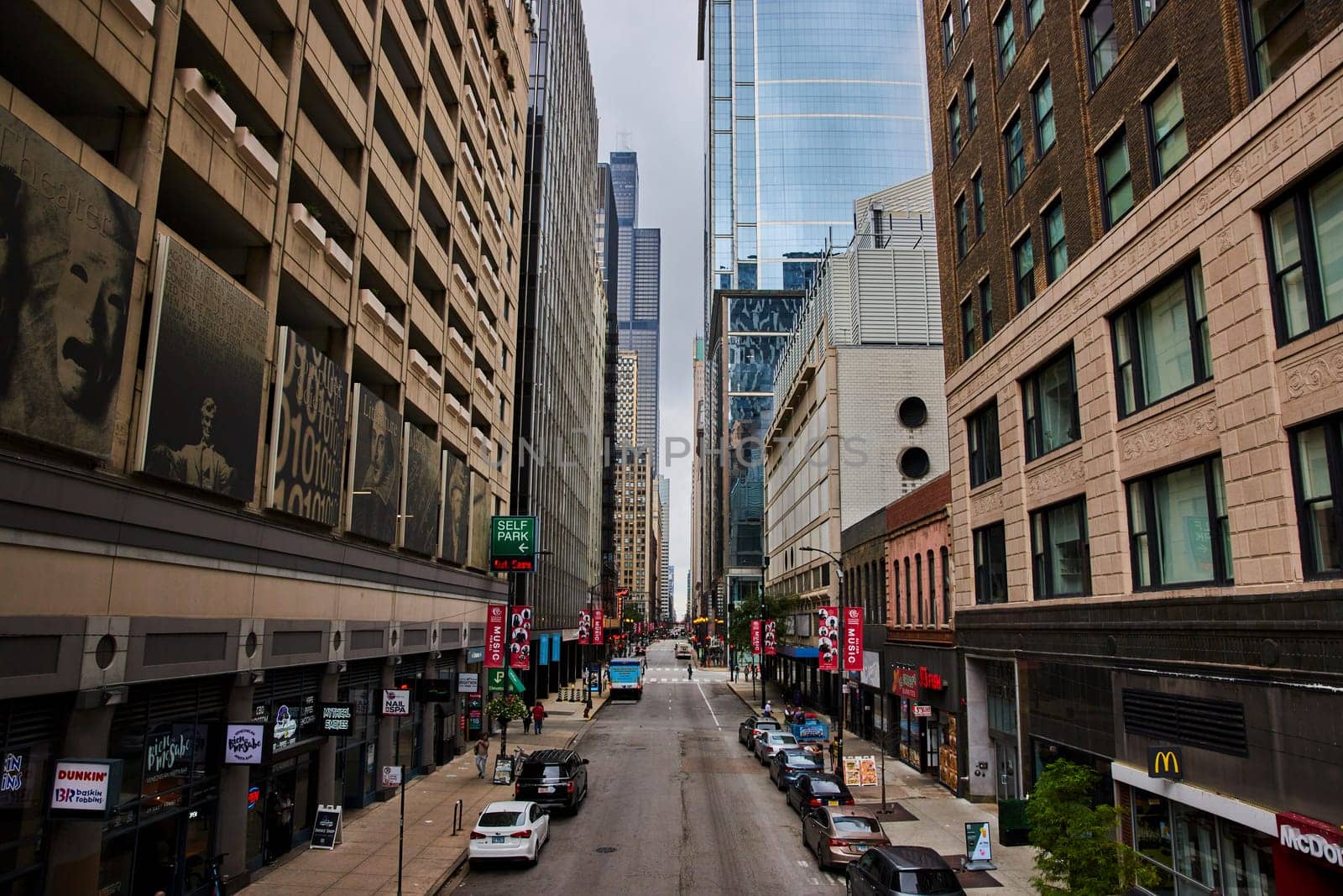 Image of Chicago, IL street corridor between city skyscraper buildings on quiet summer day, USA