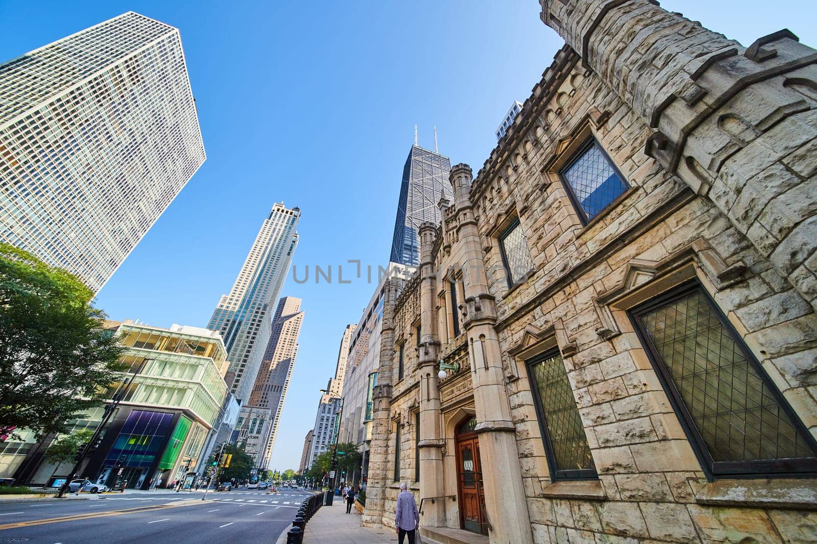 Chicago Water Works castle building side view with city skyscrapers on blue sky day, tourism by njproductions