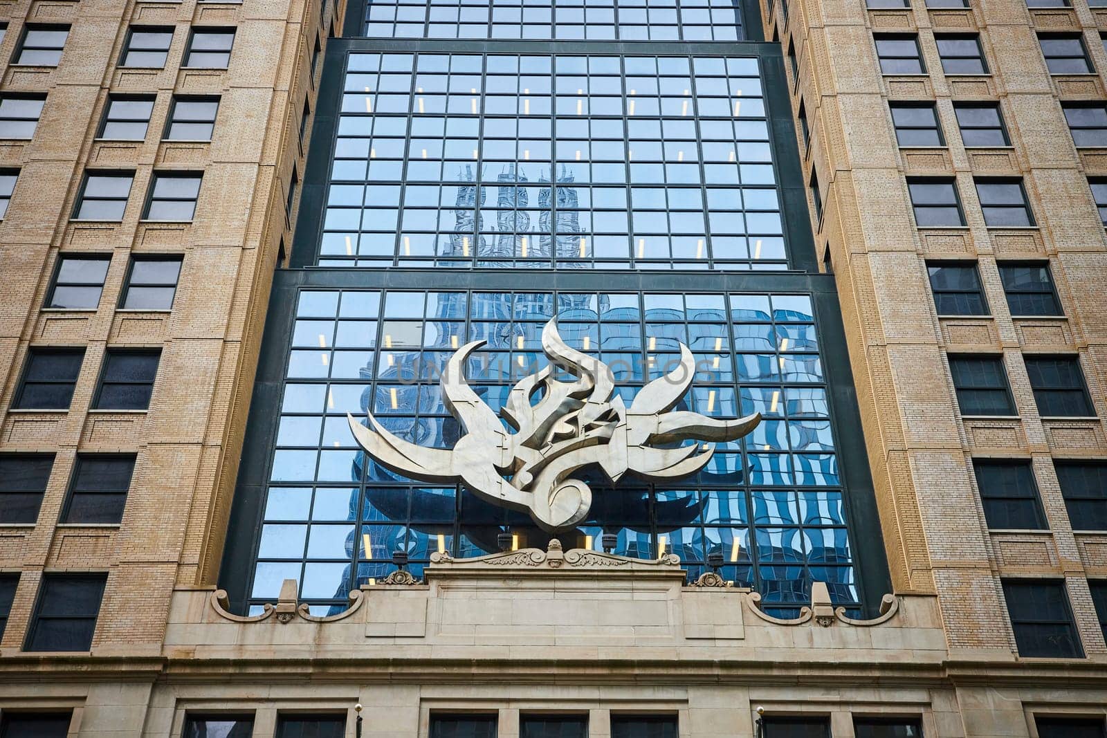 Image of Chicago public art, abstract flame sculpture on downtown building with reflective blue windows
