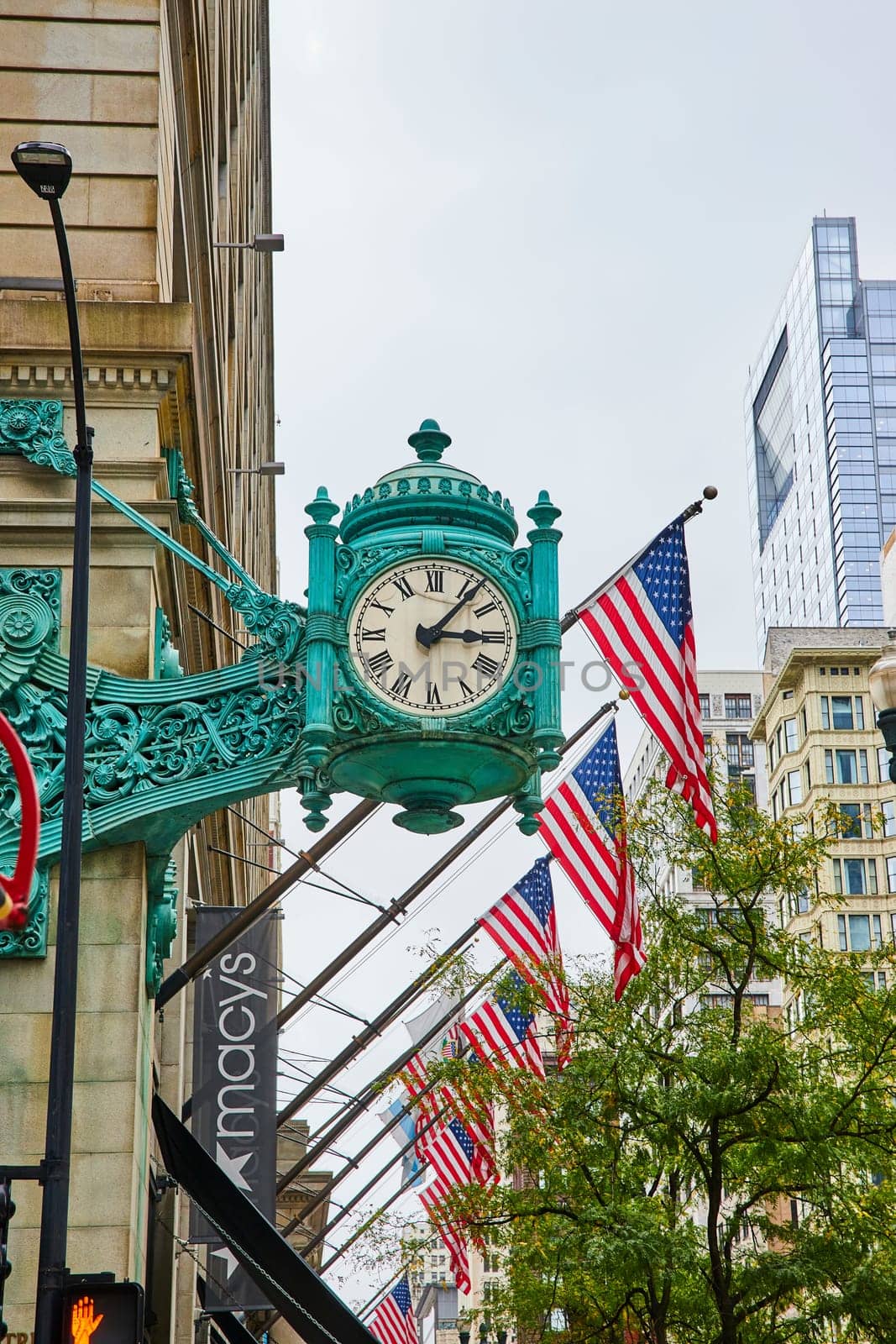 Image of Copper clock with American flags patriotic city, daylight saving time, green trees in Chicago