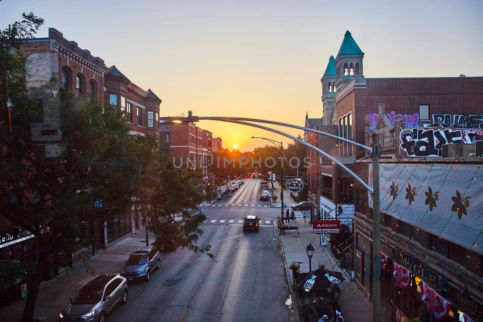 City street stretching endlessly toward golden sun over buildings at sunset, travel, tourism in US by njproductions