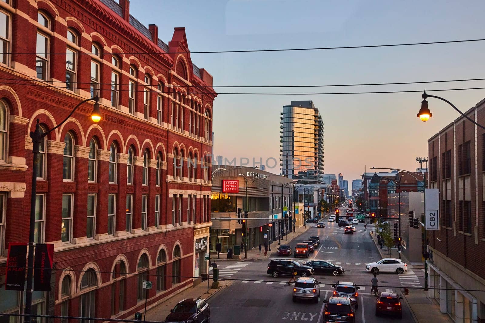 Image of Brick building beside long, endless Chicago street with buildings at sunset with street lights, IL