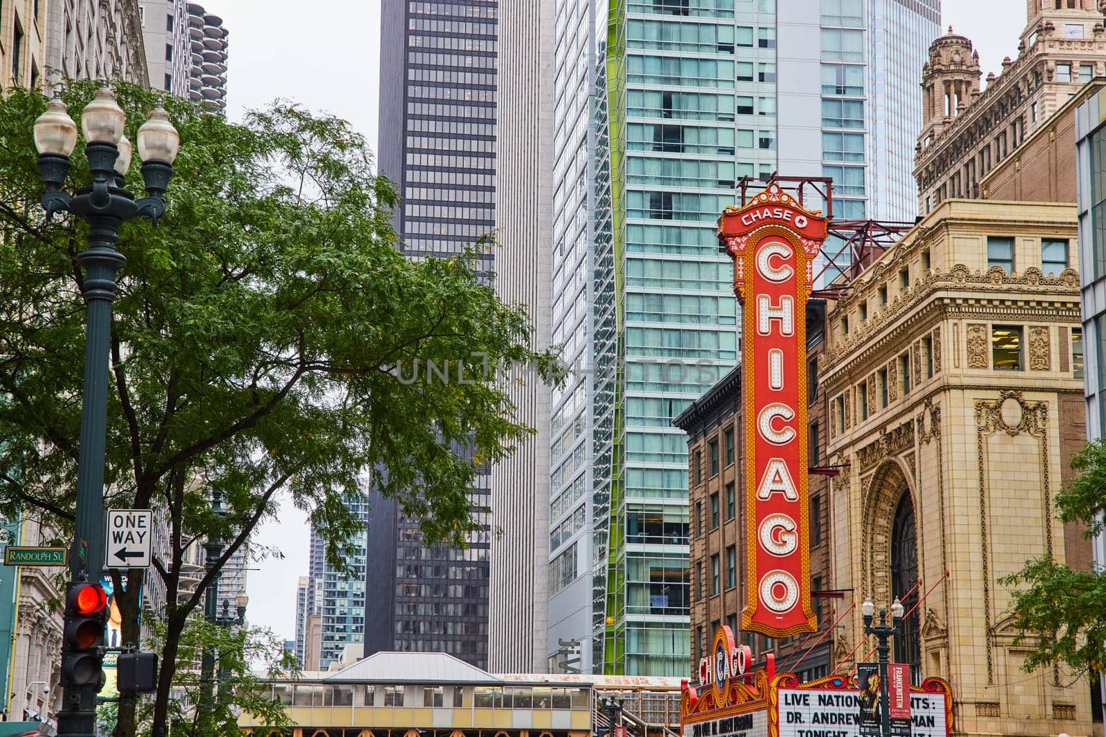 Image of Large orange sign with Chicago in white lettering in downtown of city, historic building