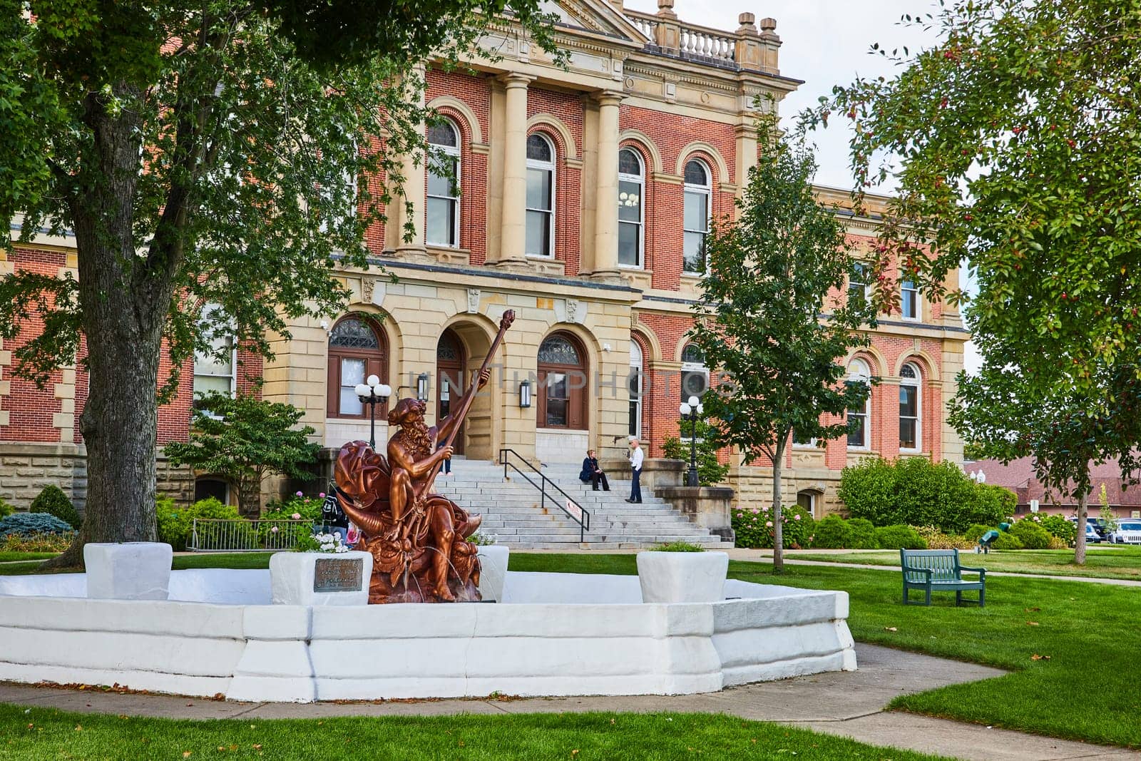 Image of Elkhart County courthouse with bronze statue of Poseidon out front on summer day, law and order