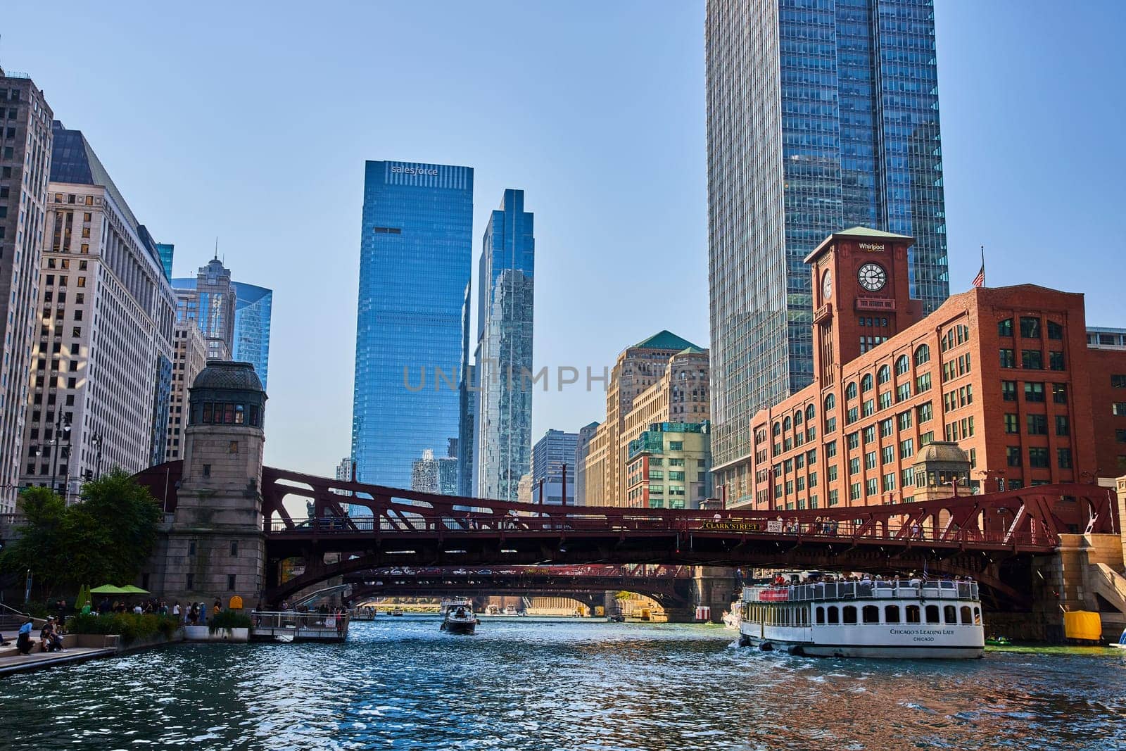 Chicago canal with tour boats under red bridges with blue skyscrapers and office buildings, summer by njproductions