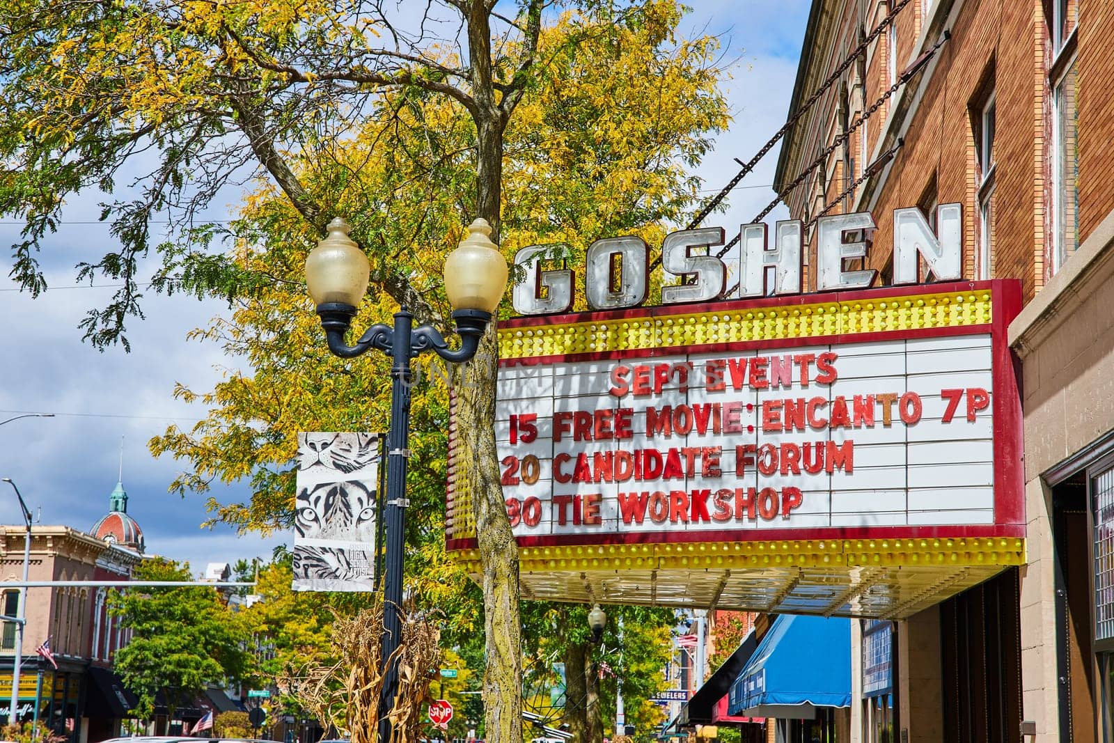 Image of Goshen theater sign on street with shops on bright, sunny summer day, Indiana