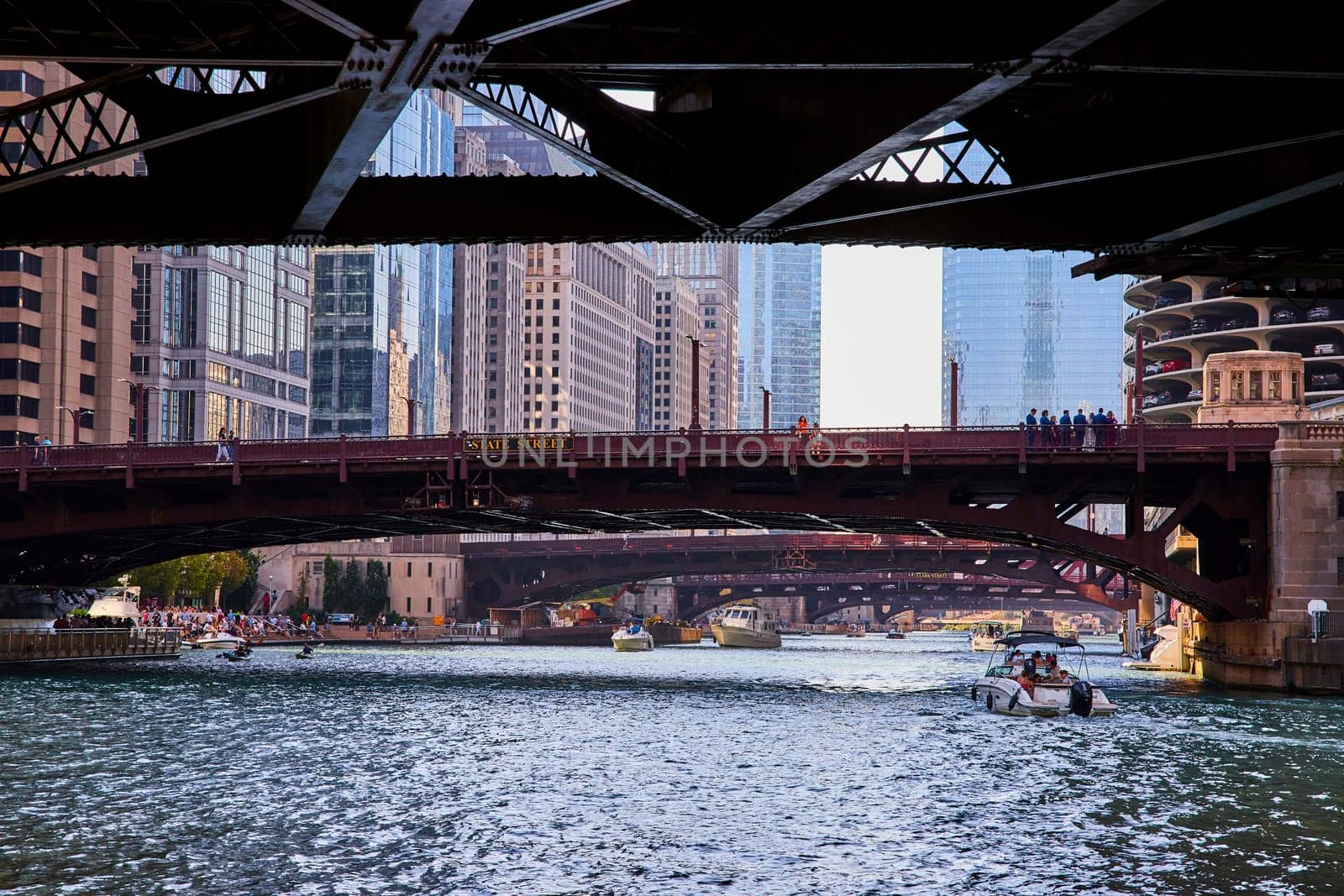 Image of Boats with tourists on Chicago, IL canal with people on State Street bridge on sunny summer day