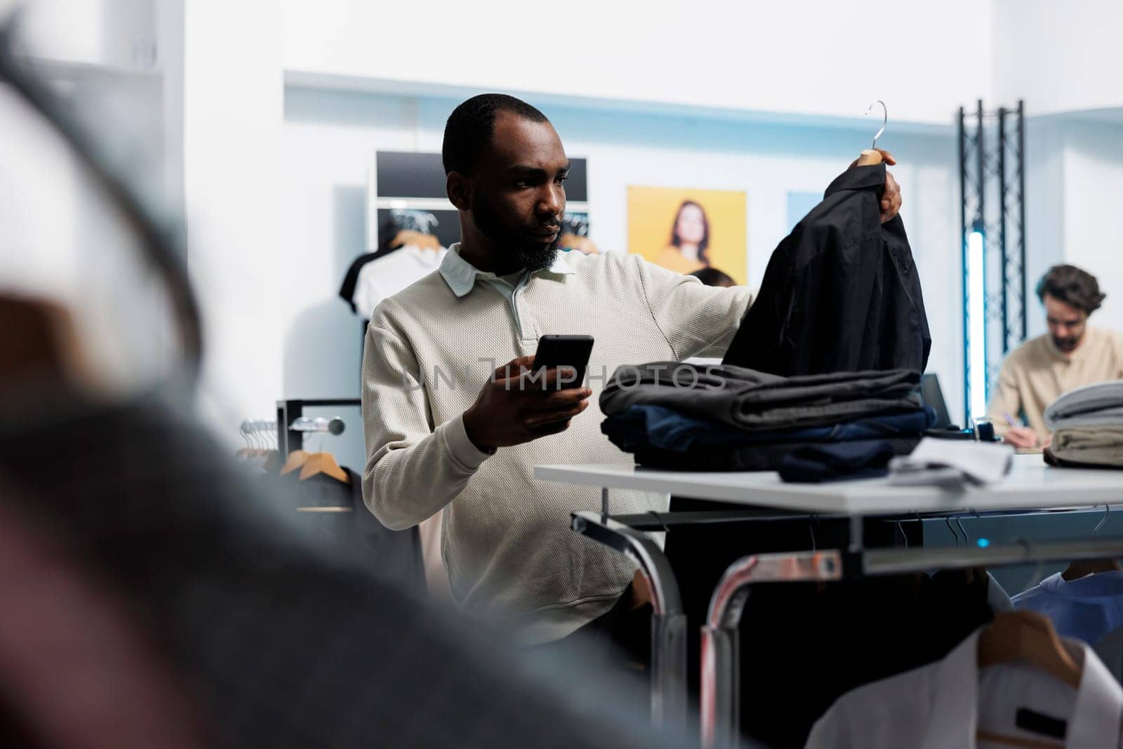 Man choosing jacket in clothing store by DCStudio