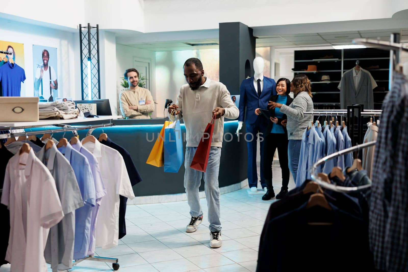 Man carrying shopping bags in store by DCStudio