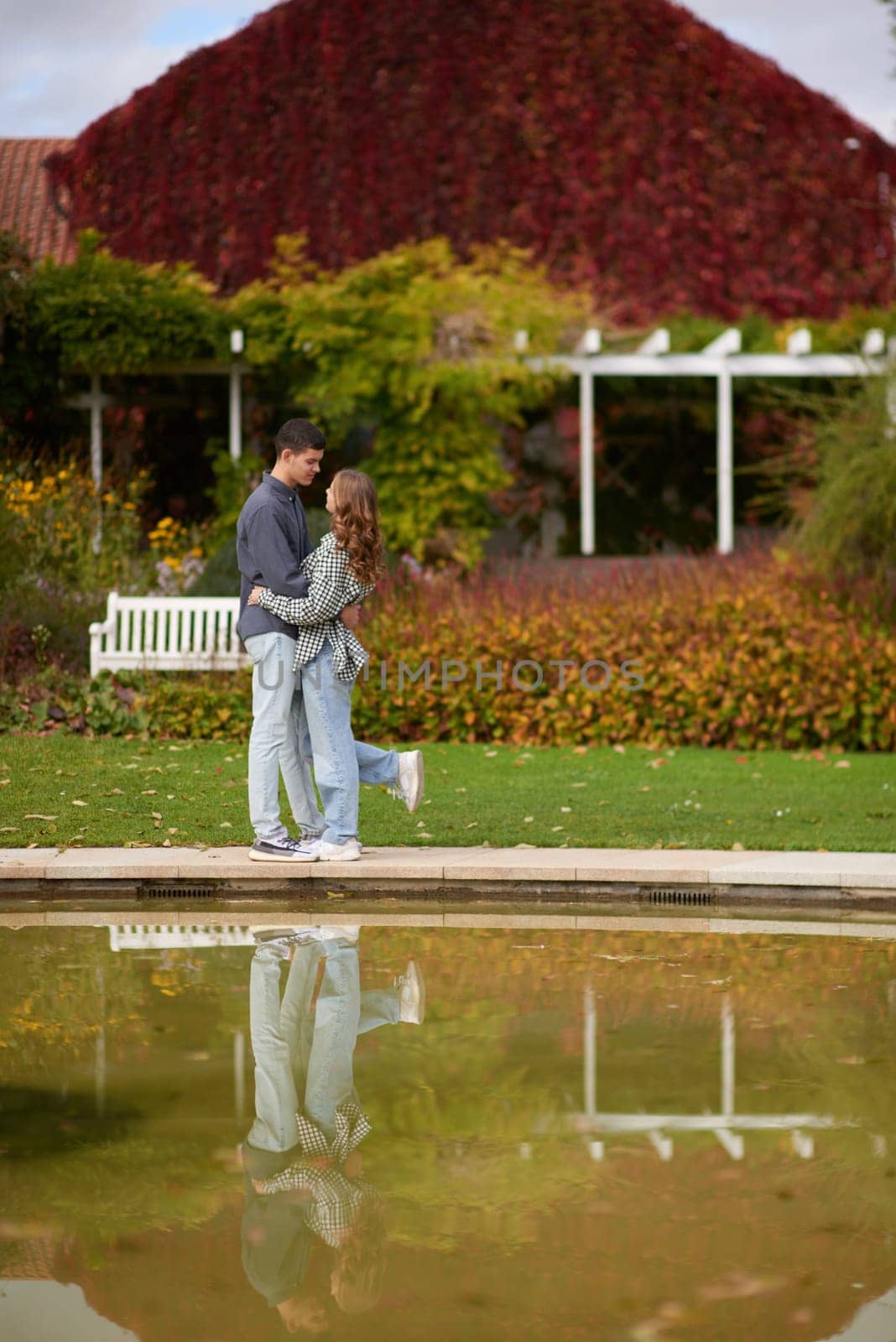 Young couple kissing and rejoices at the lake. lovely young couple kissing outdoors in autumn. Loving couple walking in nature. Autumn mood. Happy man and woman hugging and kissing in autumn. Love. Fashionable couple outdoors. Fashion, people and lifestyle. Stylish couple in autumn outfit. by Andrii_Ko