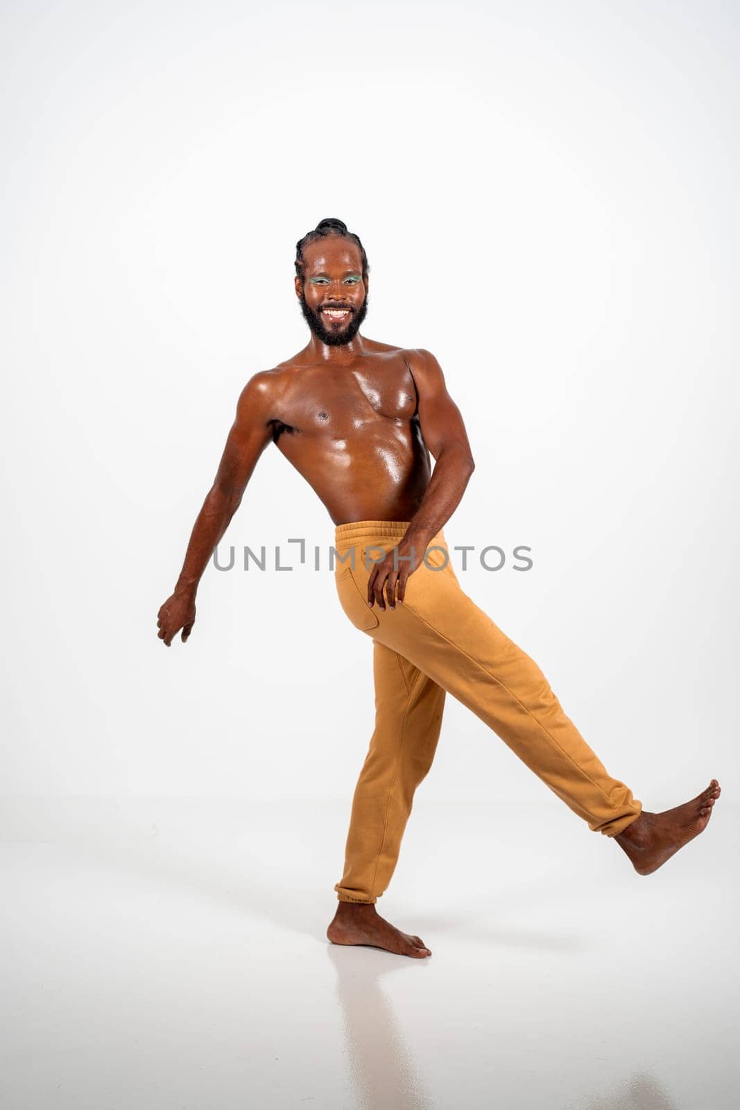 Happy barefoot shirtless african-american gay walk isolated on white background, Gay African athletic man wearing make-up walking side view. Equality concept.