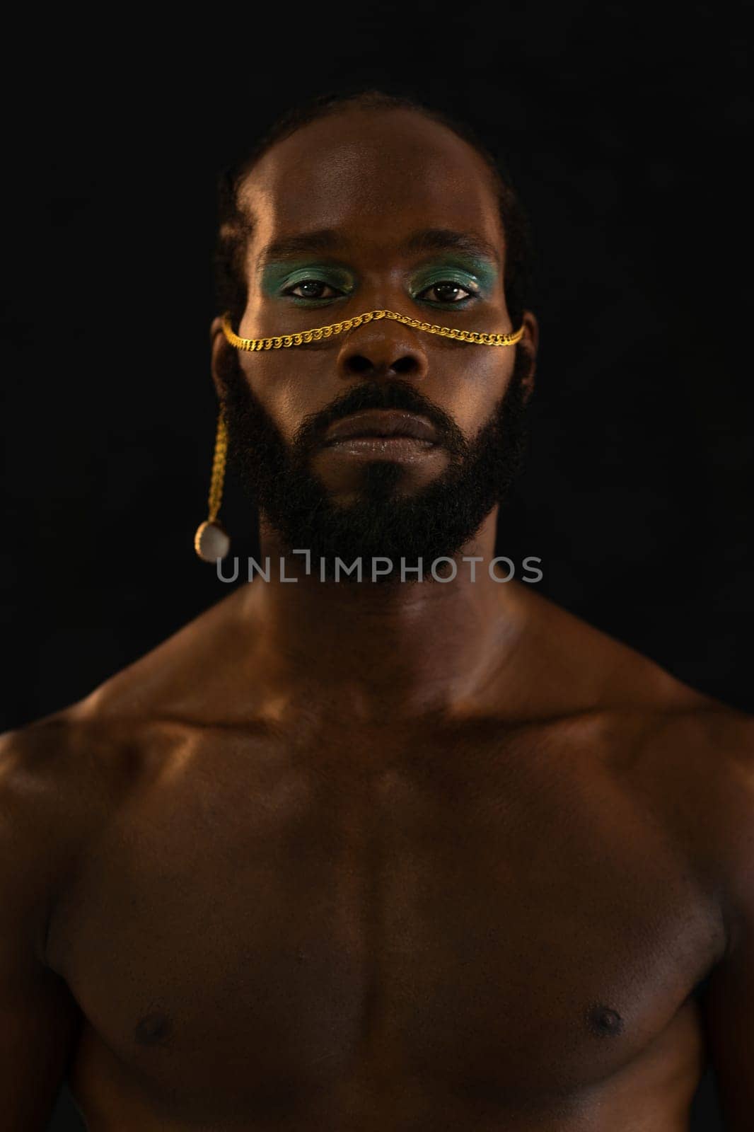 Confident african-american bearded gay man with bright makeup isolated on black background, Close up portrait. Gay African man wearing make-up looking at camera.