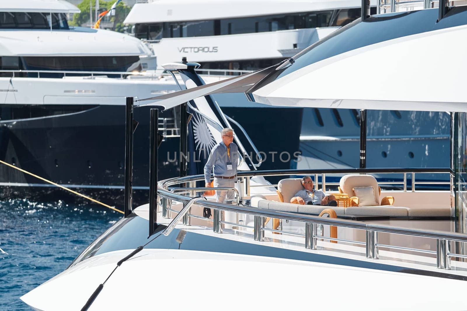 Monaco, Monte Carlo, 28 September 2022 - Invited wealthy clients inspect megayachts at the largest fair exhibition in the world yacht show MYS, port Hercules, yacht brokers, sunny weather. High quality photo