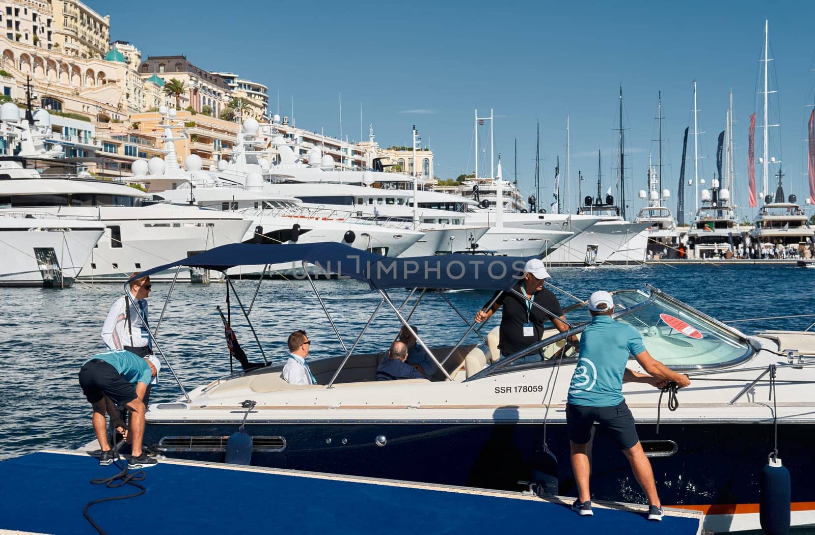 Monaco, Monte Carlo, 28 September 2022 - a motor boat with guests of yacht brokers departs from the shore in the largest fair exhibition in the world yacht show MYS, port Hercules, rich clients, sunny. High quality photo